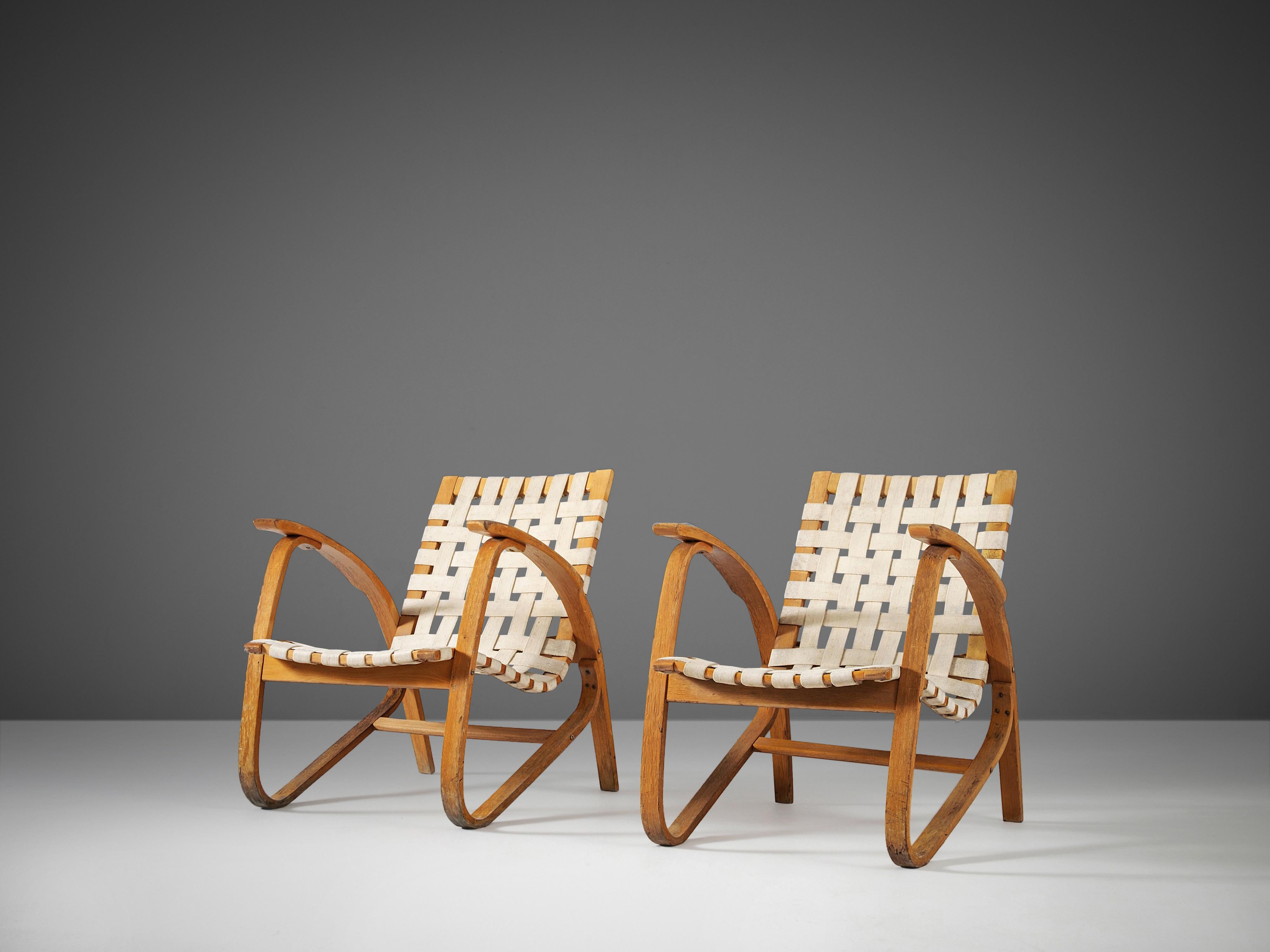 Jan Vanek for UP Zavodny, lounge chairs, wood, original canvas, Czech Republic, 1930s

Stunning pair of dynamic armchairs designed by Czech architect Jan Vanek (1891-1962). These chairs are upholstered with an off-white woven canvas seat and