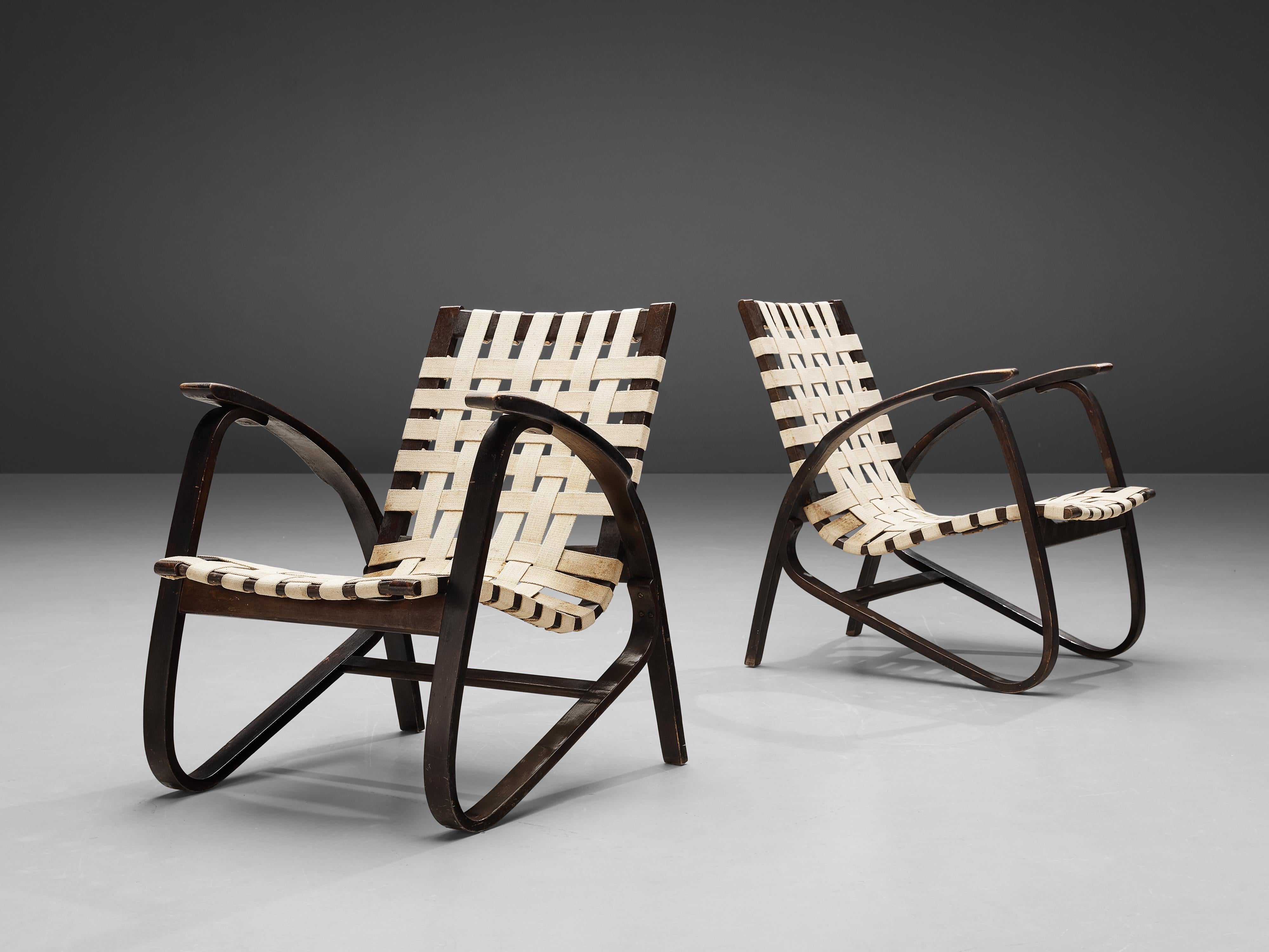 Jan Vanek for UP Zavodny, lounge chairs, wood, original canvas, Czech Republic, 1930s

Stunning pair of dynamic armchairs designed by Czech architect Jan Vanek (1891-1962). These chairs are upholstered with an off-white woven canvas seat and elegant