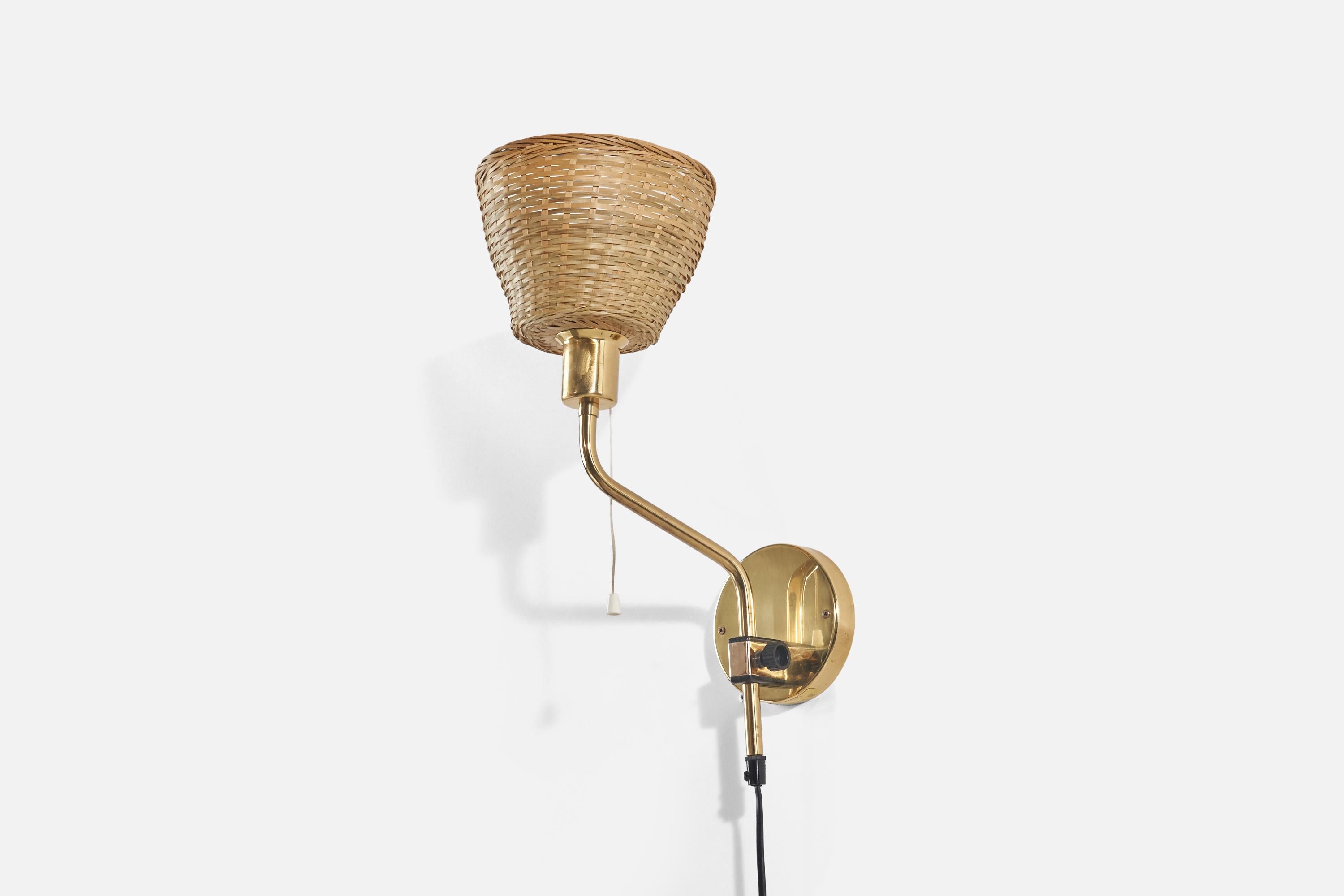 A brass and rattan, adjustable wall light designed by Jan Wickelgren and produced by Aneta, Sweden, 1970s.

Dimensions variable, measured as illustrated in first image.

Sold with lampshade(s). Dimensions stated are of sconce with
