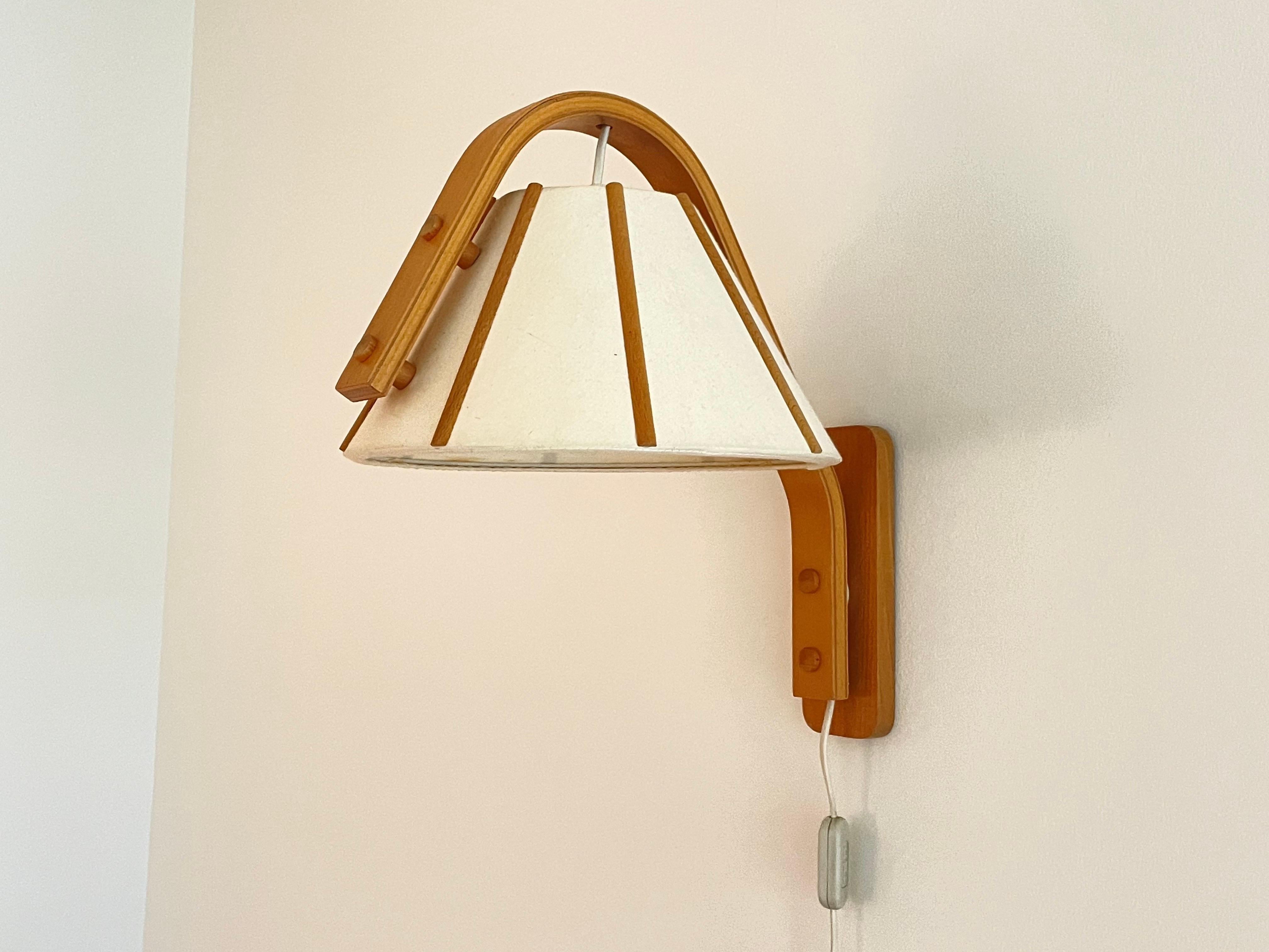 Skandinavische moderne Wandleuchte aus gebogenem Buchenholz, entworfen von Jan Wickelgren in den 1970er Jahren für Aneta Sweden.

Abmessungen (H x B): 38cm x 38cm. 
Abmessungen des Schirms (D): 29 cm. 
Leuchtmittel: E26/E27 Schraubglühbirne, max.