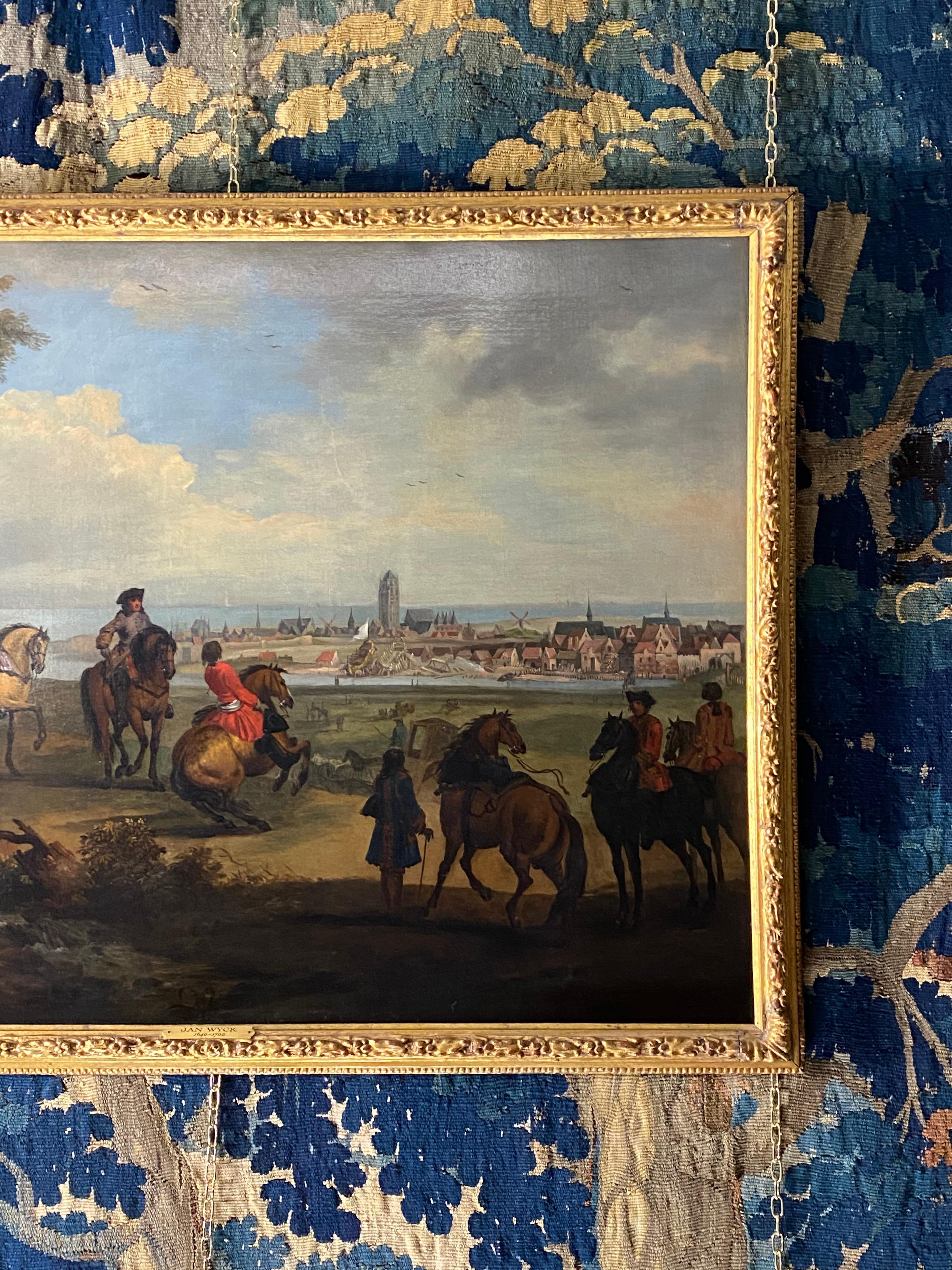 We are thrilled to offer this fine and highly detailed early eighteenth-century equestrian oil by an artist in the circle of Jan Wyck (1640-1702)

It depicts riders on their horses with handlers in a rustic dune landscape, in the background is a