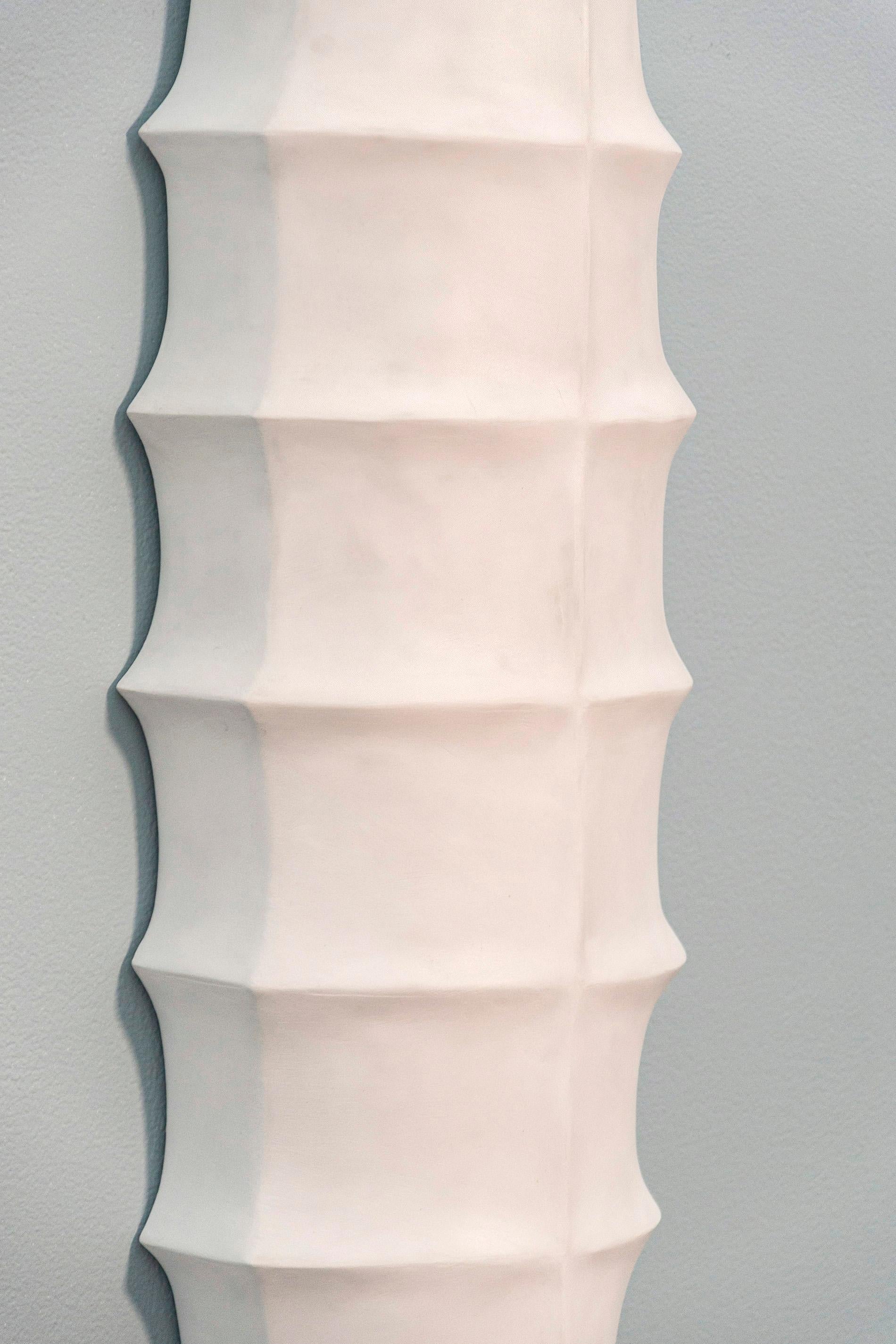 Inspired by the organic shapes, colours and textures of the natural world, Jana Osterman creates stunning wall reliefs. This bright white plaster piece features an elegant, elongated shape and raised ridges. A wax polish on the plaster gives it a