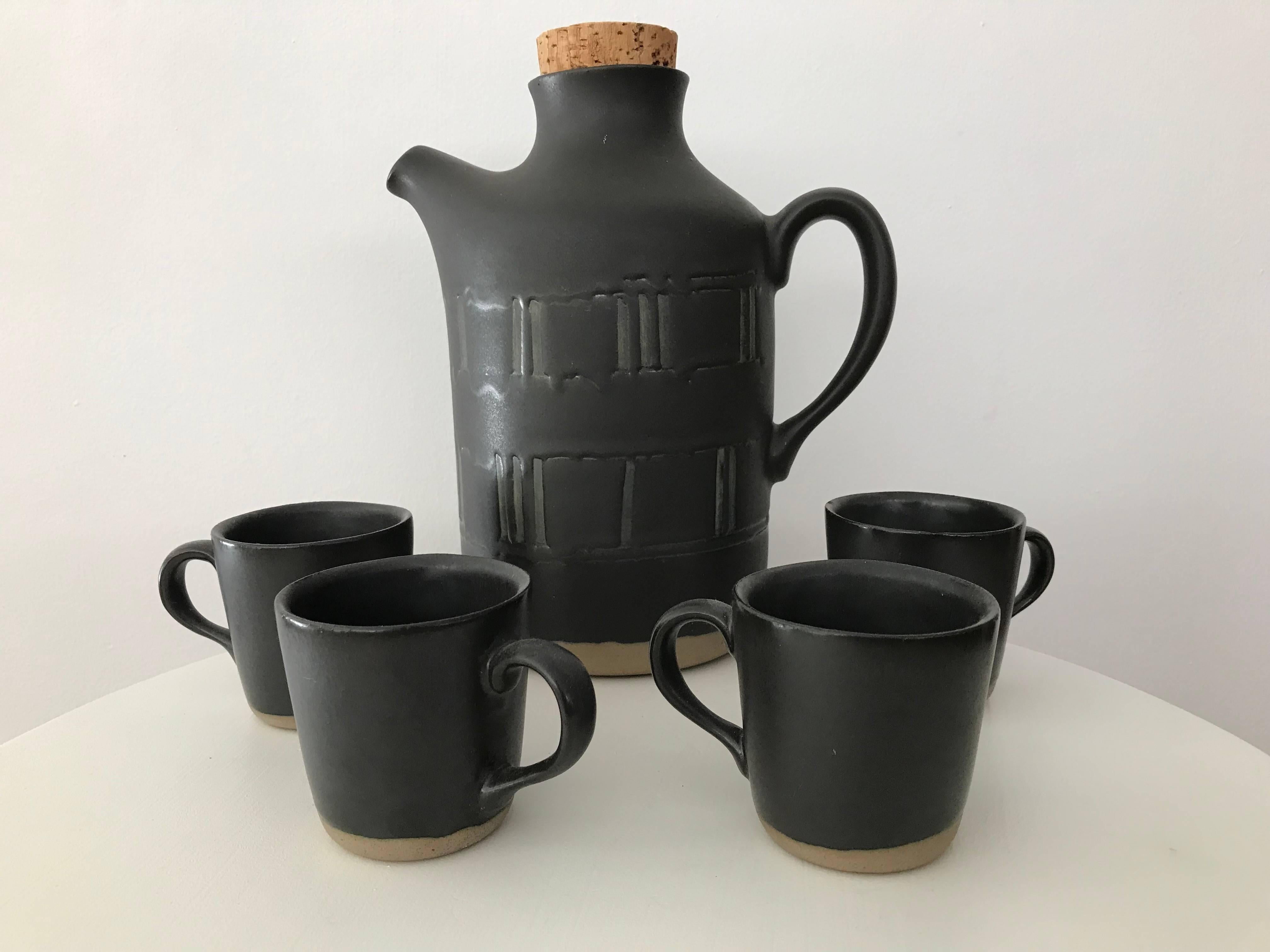 A very nice serving set with a pitcher and four cups by Jane & Gordon Martz for Marshall Studios. Very nice condition with original cork stopper. Pitcher and one cup still have labels. Once cup has a small nick at the rim. Each cup is: four inches