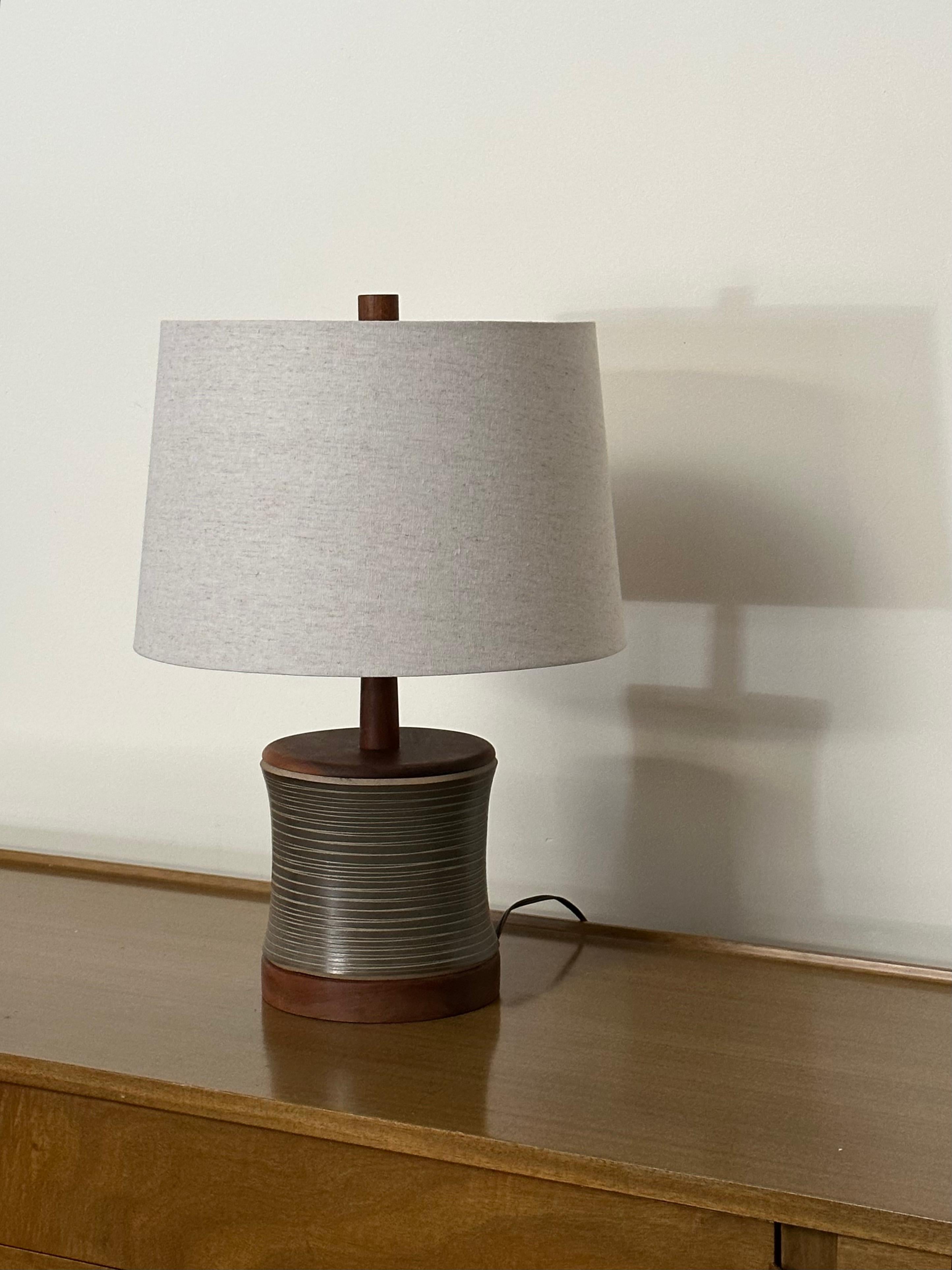 Iconic table lamp designed by the ceramicist duo Jane and Gordon Martz for Marshall Studios. Featuring a walnut disc bottom and top, complete with beautifully glazed ceramic body. An extra long walnut neck completes the lamp.
