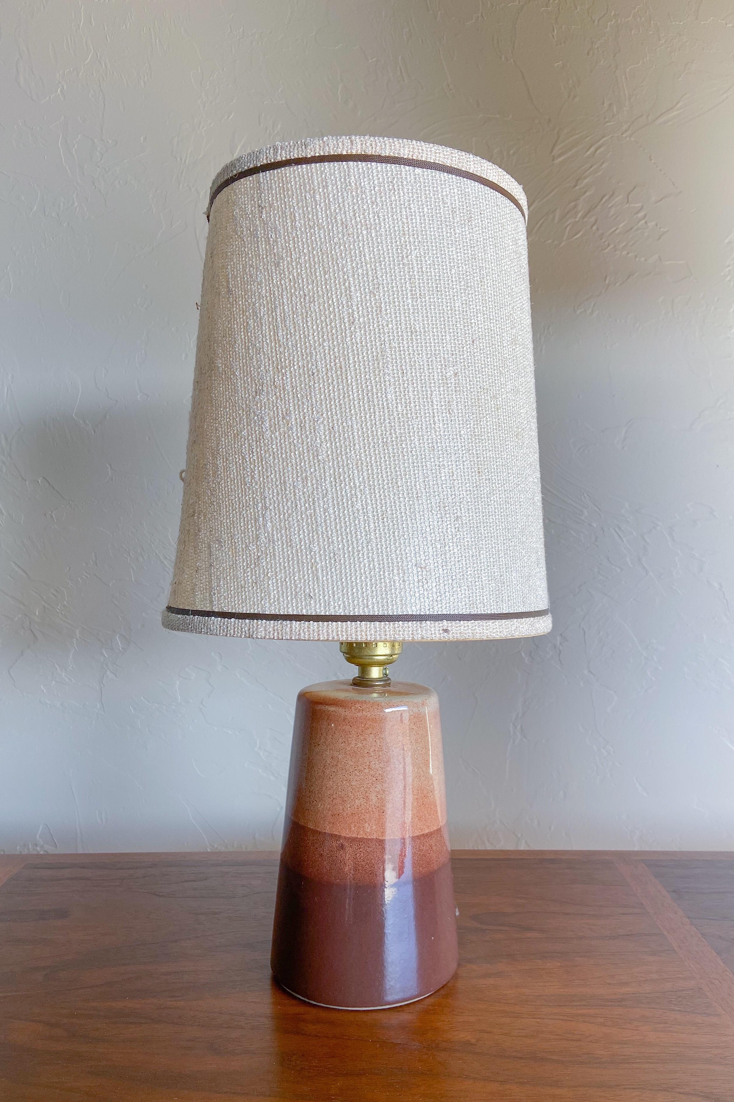 A lovely petite table lamp by Gordon and Jane Martz for Marshall Studios. 

Featuring three shades of lovely speckled brown glaze and the original nubby off-white shade. 

*Dimensions listed are with shade included.
   