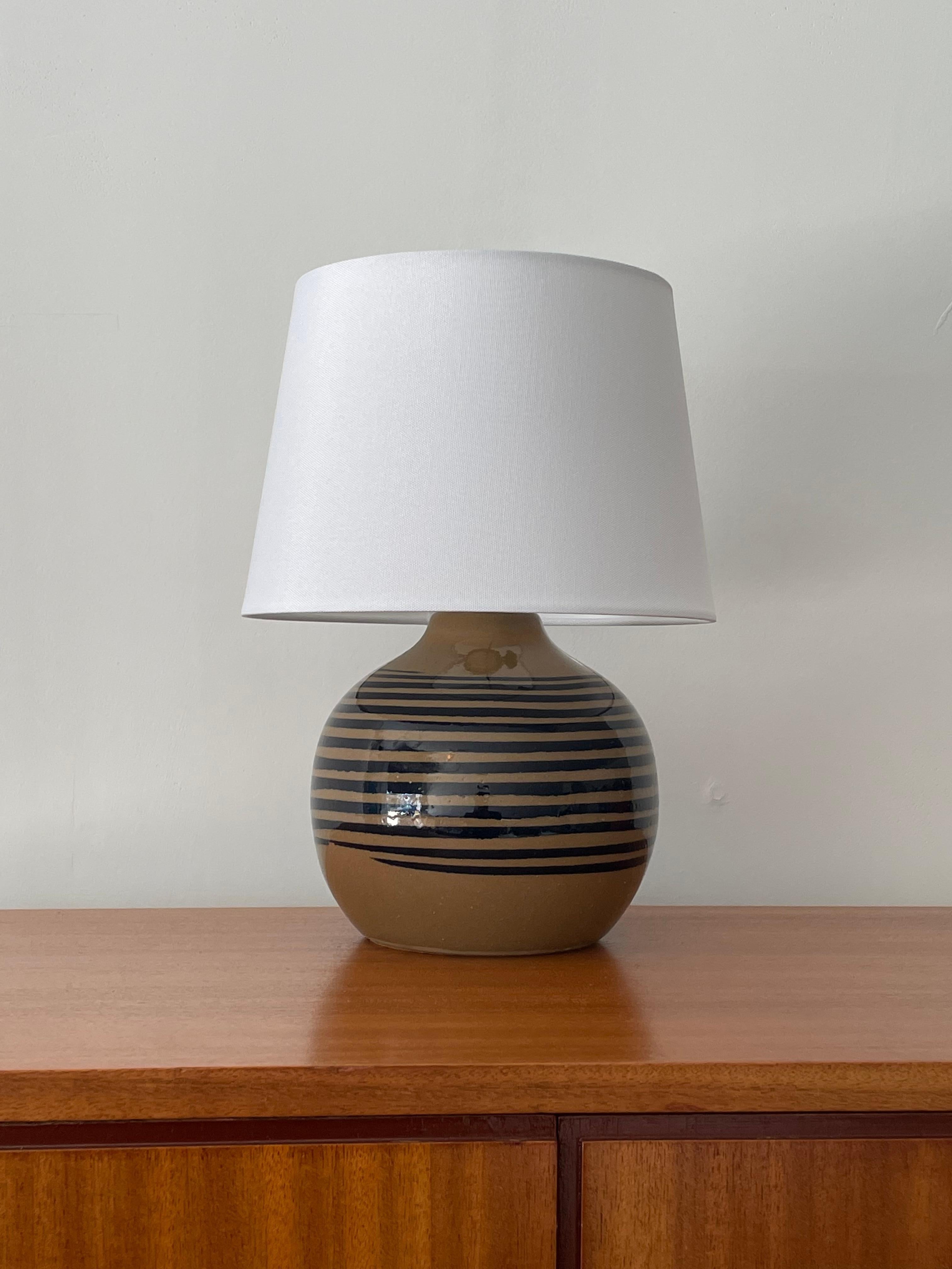 Excellent ceramic lamp by famed ceramicist duo Jane and Gordon Martz for Marshall Studios. Features an unusual color palette. Complete with new shade and newer wiring.

Overall:
13.5” tall
 10” wide

Ceramic portion:
7” tall
7.5” wide.