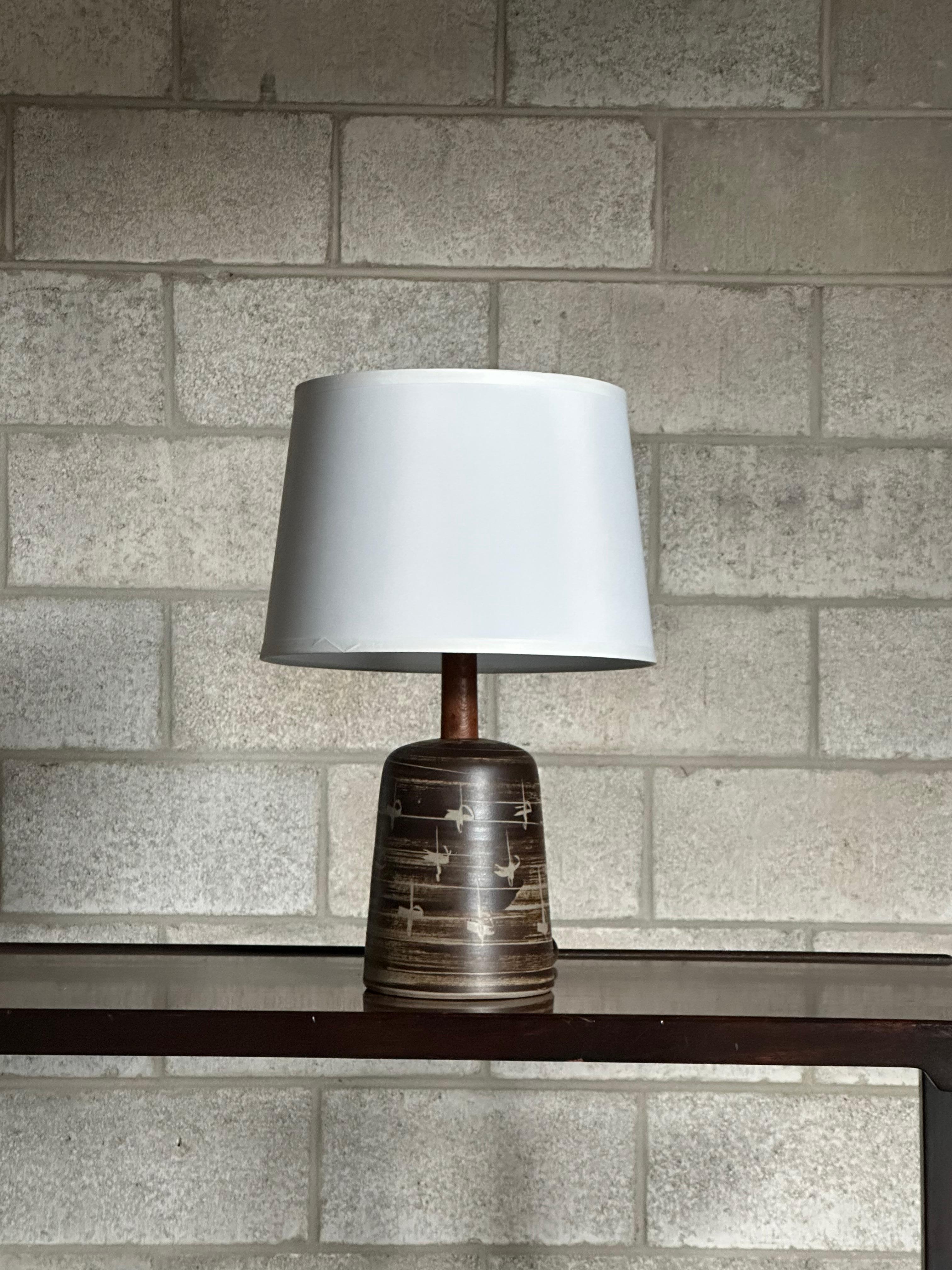 Table lamp designed by Jane and Gordon Martz for Marshall Studios. Featuring a ceramic body, accented with a long walnut neck, and finished with a walnut finial. 

Overall Dimension
20.5” tall
13” wide with shade

Ceramic only dimensions 
8.5
