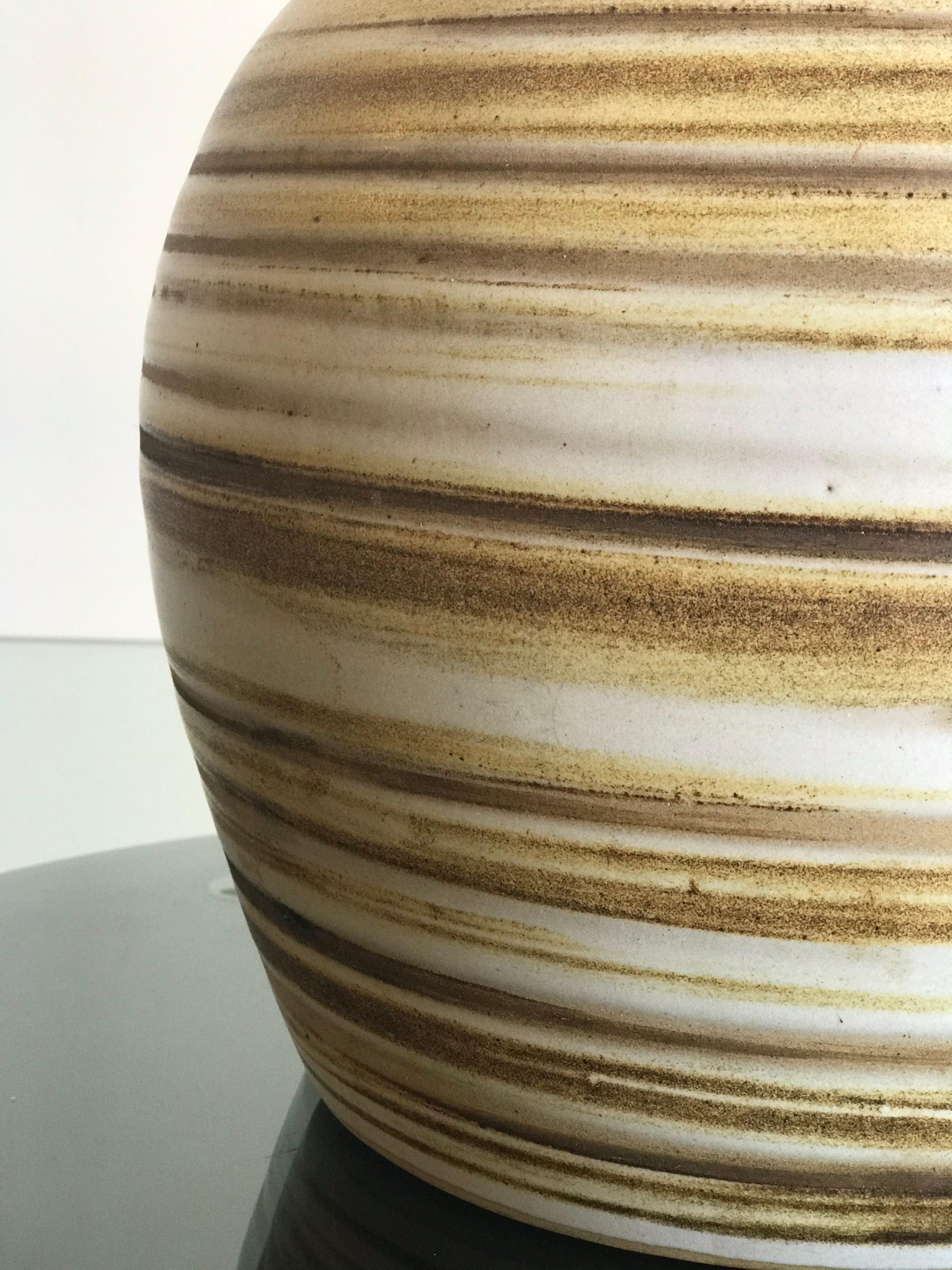 Beautiful round lamp by ceramicist duo Jane and Gordon Martz for Marshall Studios. Lovely matte glaze with swirls of gold, yellow, and tan hues. New shade, new harp, and a replacement finial. 


Ceramic 
9” across
11.5” tall

Overall 
15”