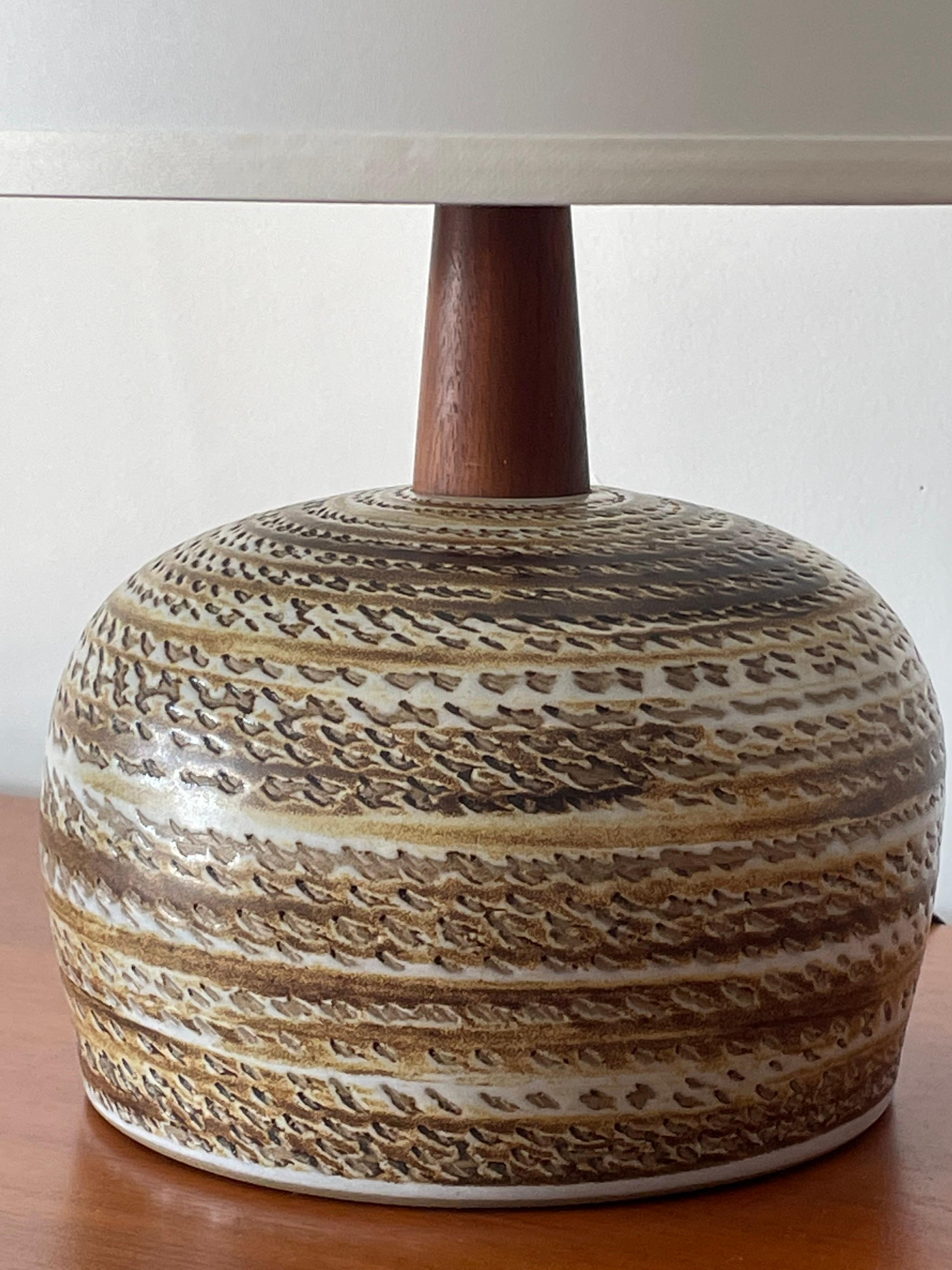 Table lamp designed by famed ceramicist duo Jane and Gordon Martz for Marshall Studios. Ceramic base with walnut neck and finial.

Dimensions:
Overall
17.5” tall 
13” wide

Ceramic Portion
5.5” tall
7.75” wide.

Shade is shown for illustrative
