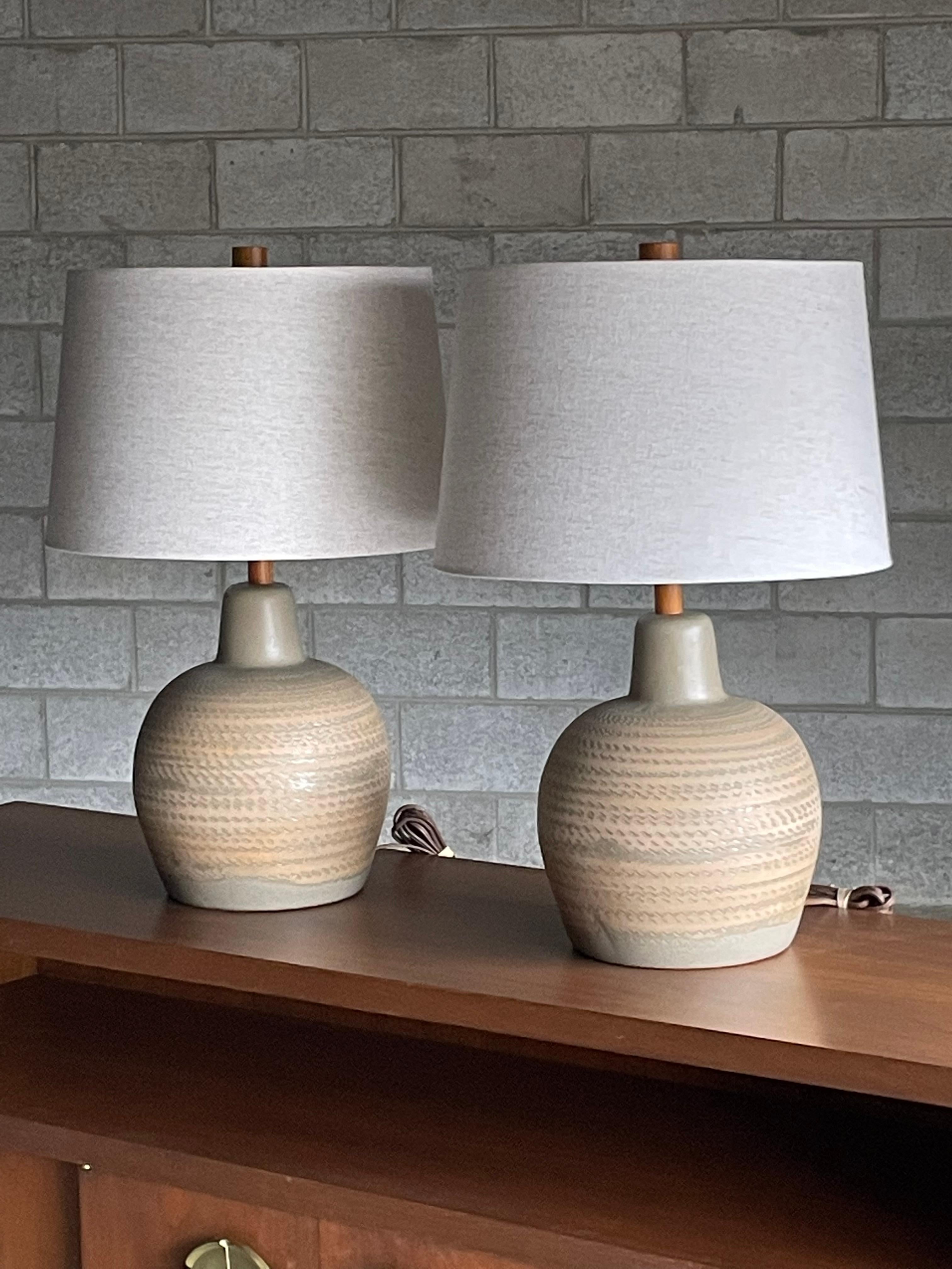 Unusual ceramic table lamps by famed ceramicist duo Jane and Gordon Martz for Marshall Studios. Wonderful matte light green color with blue speckles and tan stripes. 

Overall:
23.5” tall 
15” wide

Ceramic 
11.5” tall
9.5” wide.