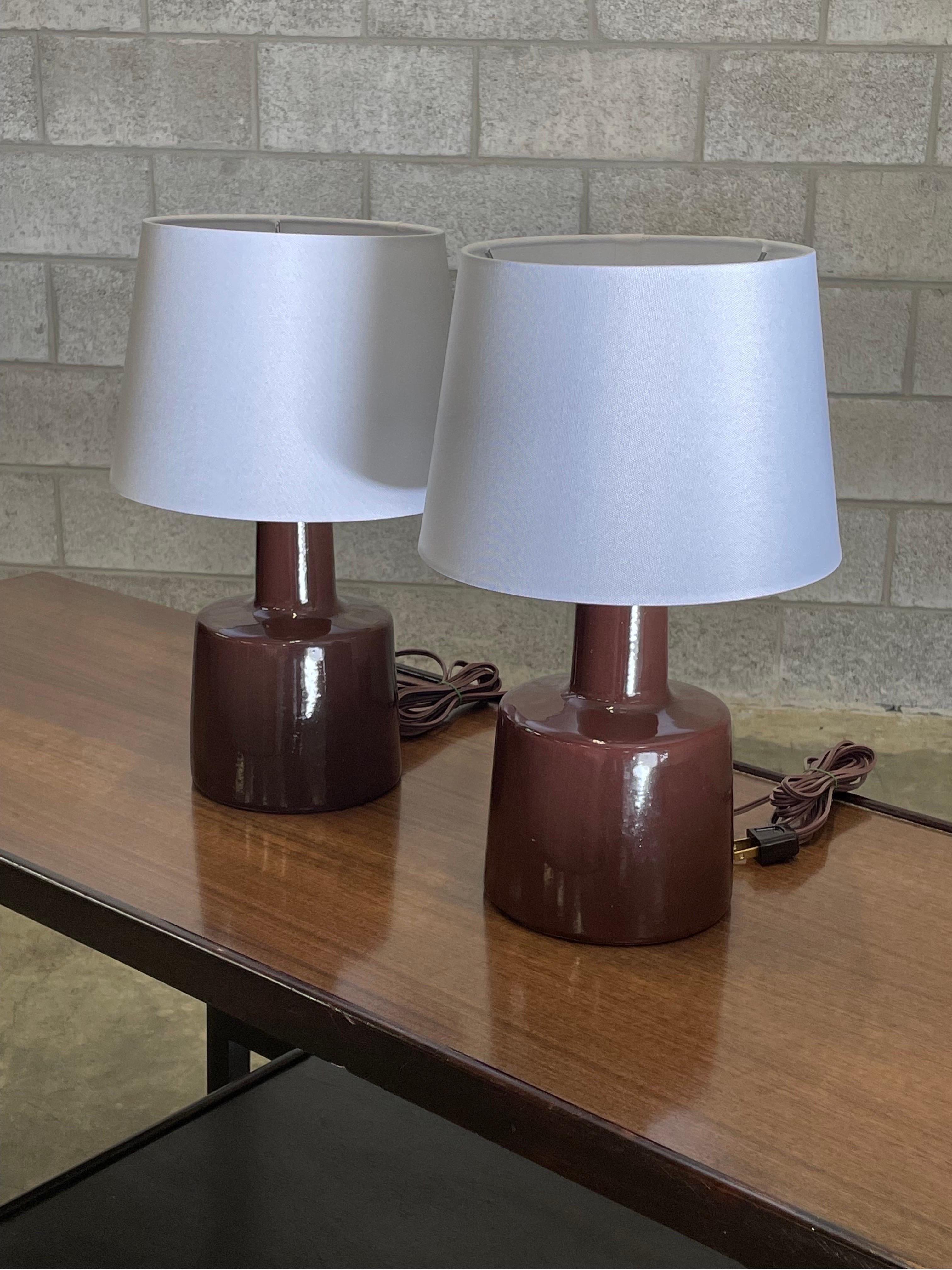 Table lamps designed by ceramicist duo Jane and Gordon Martz for Marshall Studios. Color is dark red/ brown, almost as if a wine.

Overall dimensions: 16” tall 10” wide.
Ceramic portion only 9” tall 6” across.

Shade is shown for illustrative