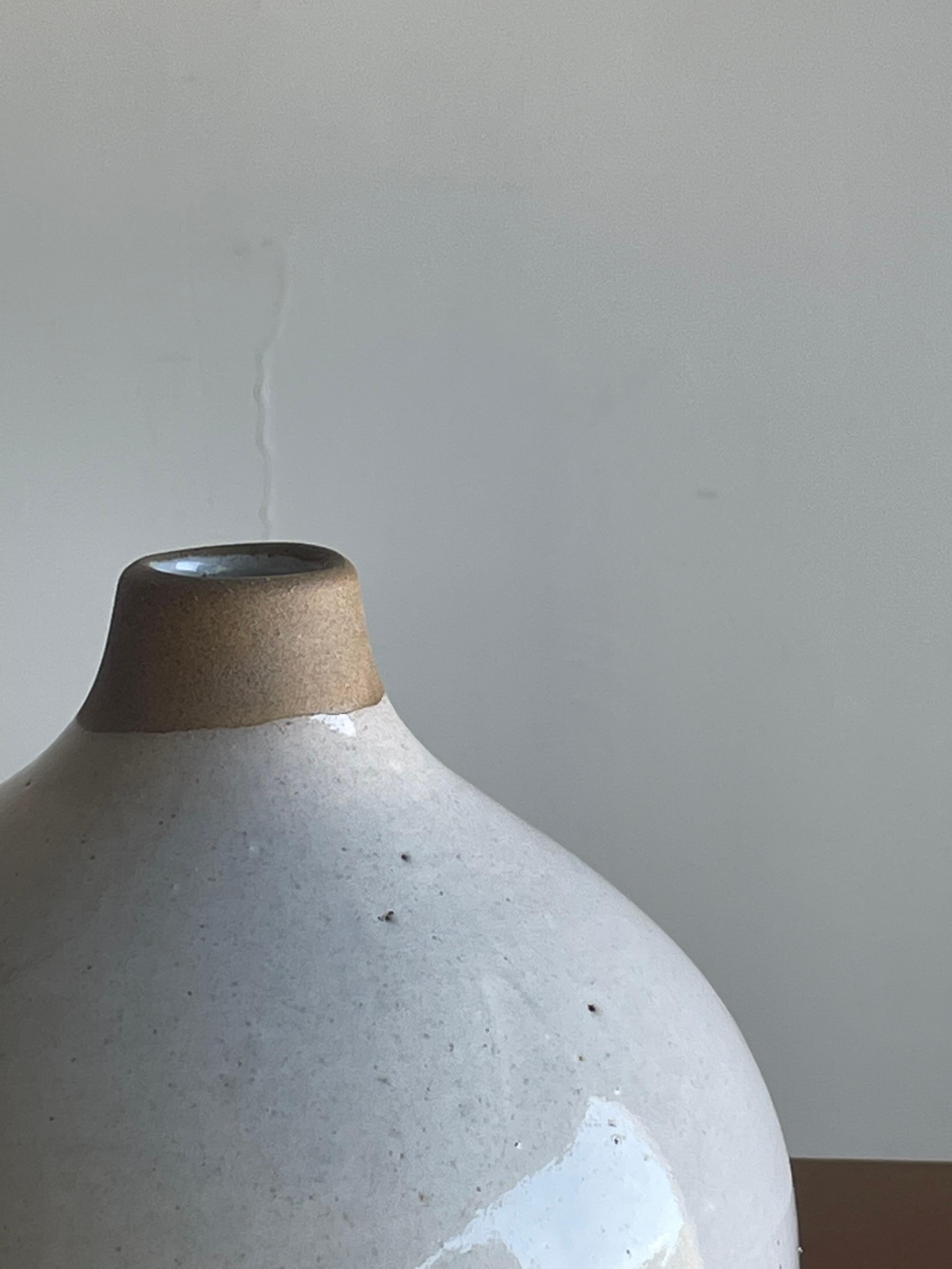 Un grand vase rond conçu par Jane et Gordon Martz pour les studios Marshall. Célèbre pour ses lampes de table en céramique très recherchées, cette collection propose un vase en céramique. Merveilleuse palette de couleurs blanc et feu (non émaillé).