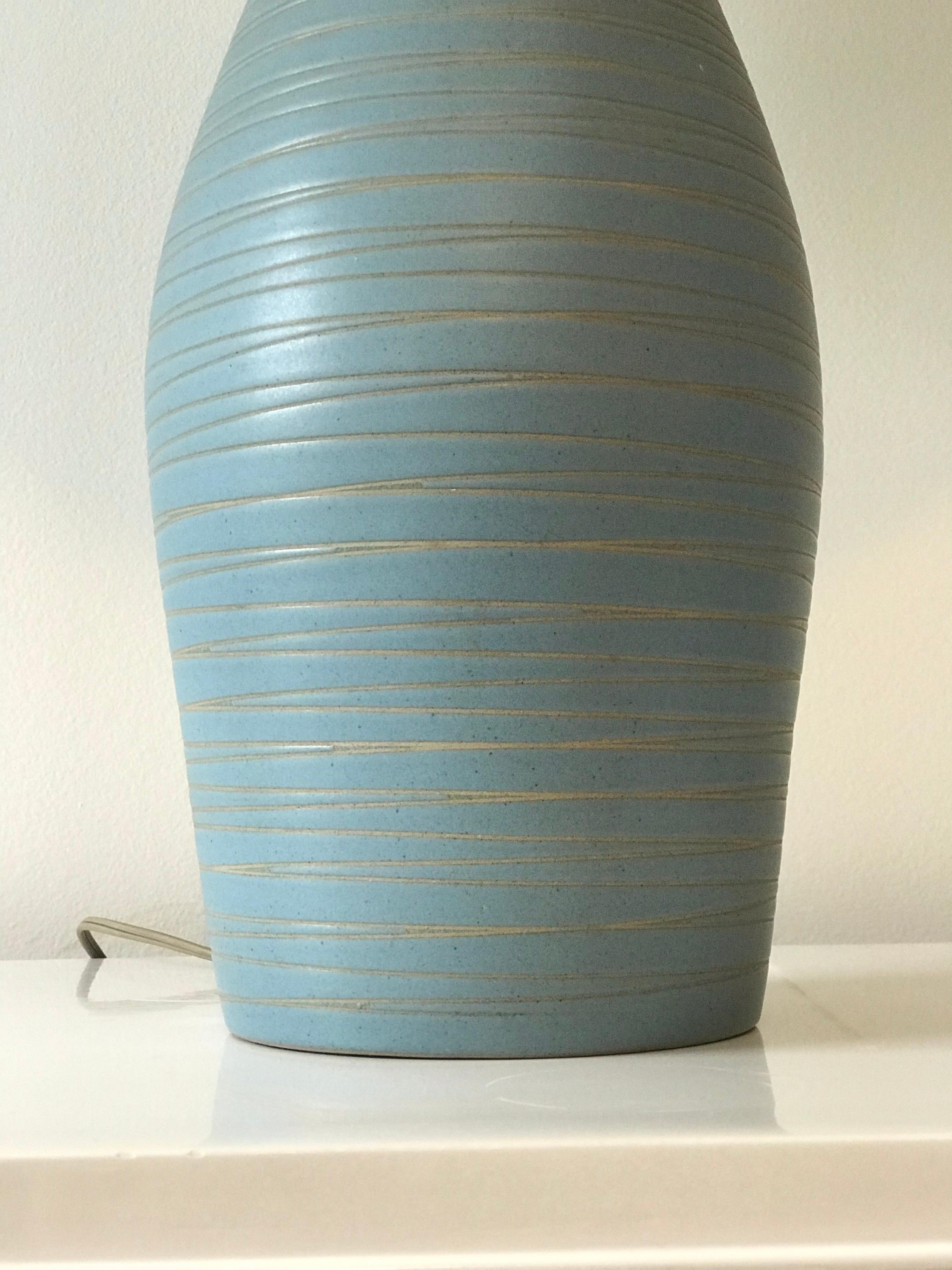 Stunning robin's egg blue lamp with incised detail by ceramicist duo Jane and Gordon Martz. Beautiful form and color with signature wood neck and finial.

Measures: Overall height 27