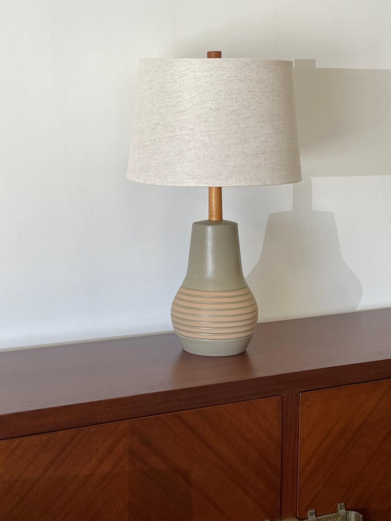 Unusual ceramic table lamp by famed ceramicist duo Jane and Gordon Martz for Marshall Studios. Wonderful matte light green color with blue speckles and tan stripes. 

Measures: Overall
26.5