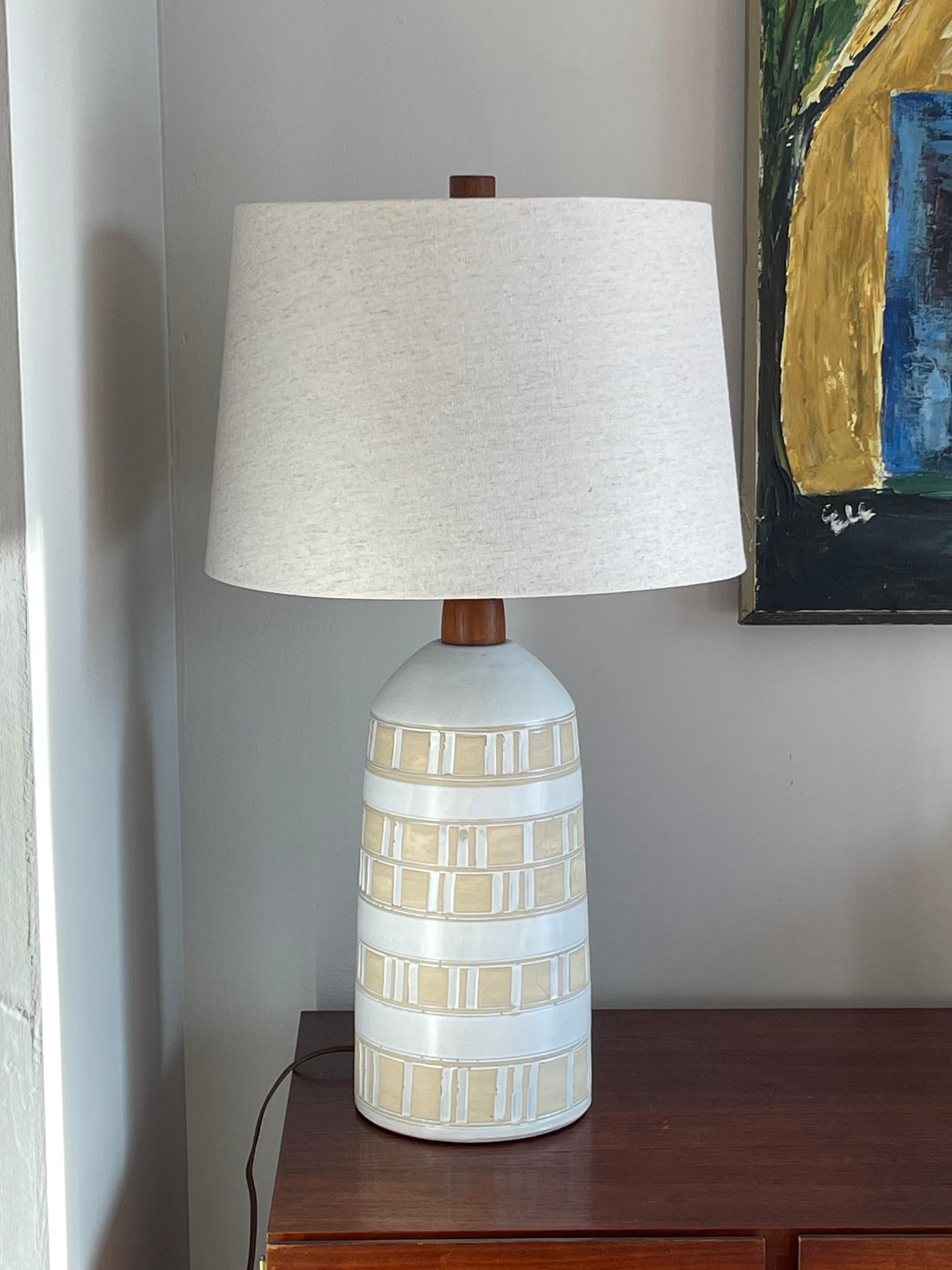 Wonderful minimalist table lamp designed by Jane and Gordon Martz for Marshall Studios. Features an organic palate with off white and bisque portions. Walnut neck and finial.

Overall
27” tall
15” wide

Ceramic 
13.75” tall
6.75” wide.