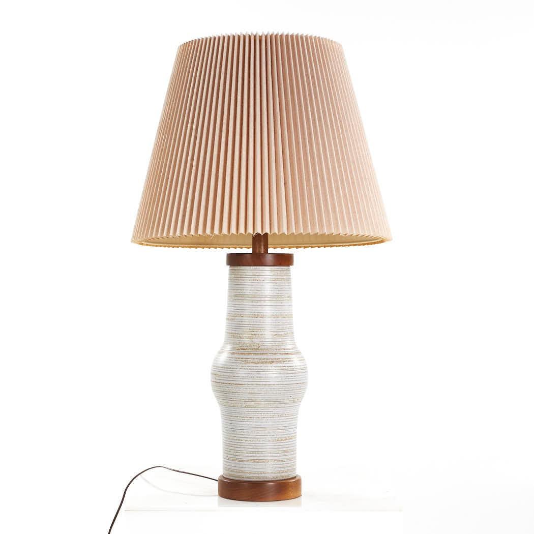 Jane and Gordon Martz Mid Century Ceramic and Walnut Lamp

This table lamp measures: 19.5 wide x 19.5 deep x 33.75 inches high

We take our photos in a controlled lighting studio to show as much detail as possible. We do not photoshop out blemishes.