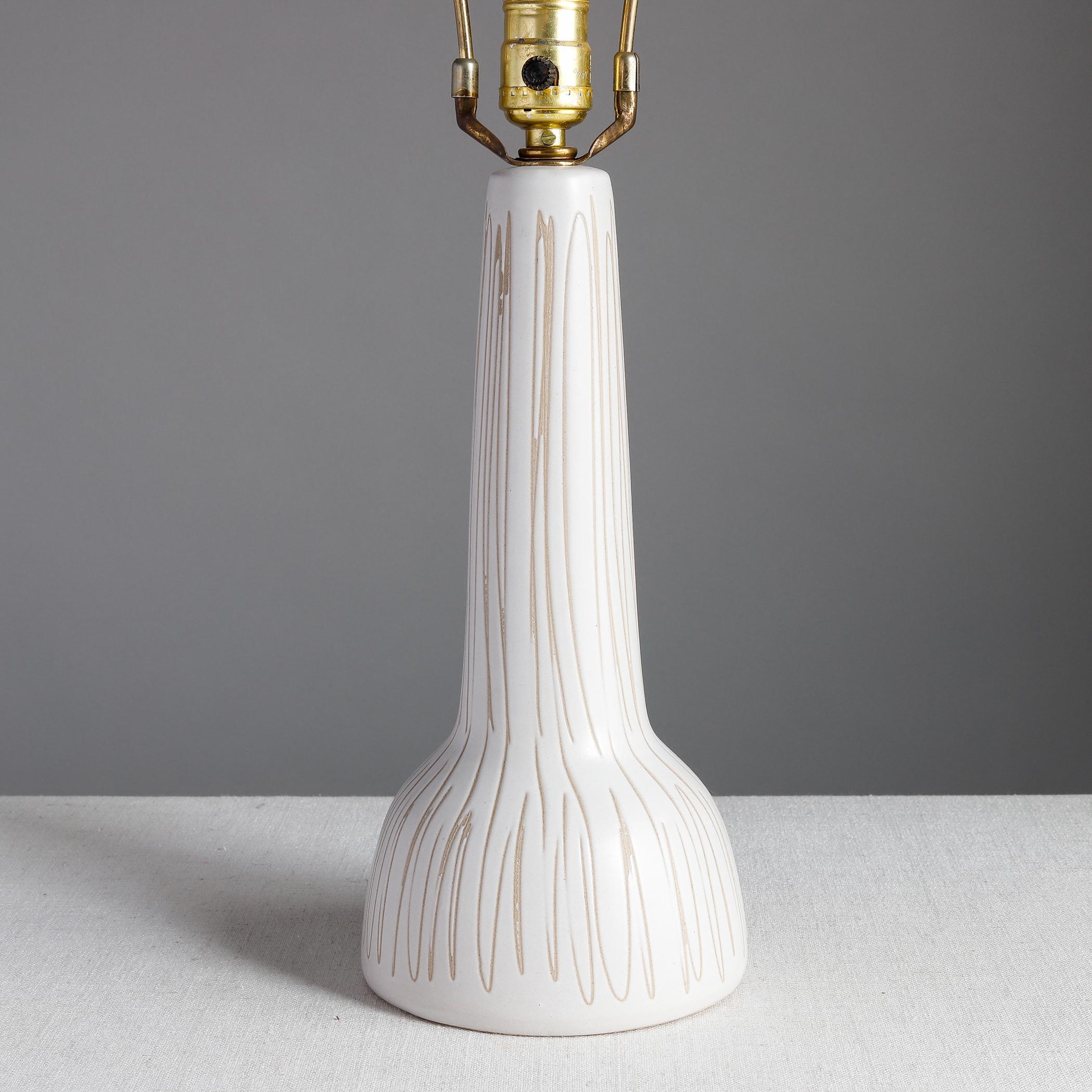 Midcentury ceramic table lamp designed by Jane and Gordon Martz for Marshall Studios of Veedersburg, Indiana. The stoneware body has a warm white glaze with hand-incised vertical lines. Signed at the back near the cord hole and with Marshall Studios