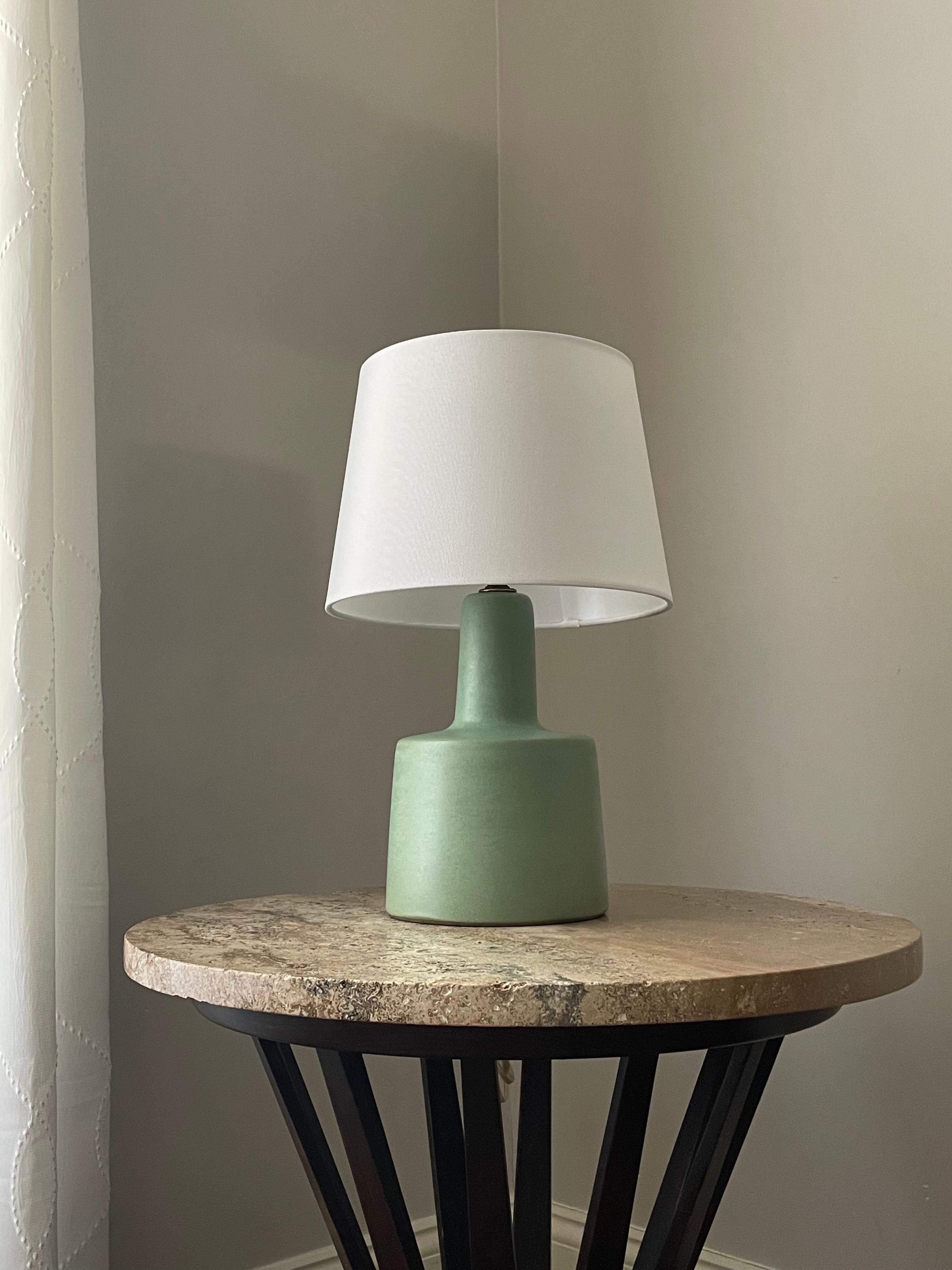 An iconic table lamp designed by famed ceramicist duo Jane and Gordon Martz for Marshall Studios. This particular one being in a unique color (seafoam green) with matte glaze. 

Overall 
16” tall 
10” wide. 

Ceramic 
9.25” tall 
6” wide.
