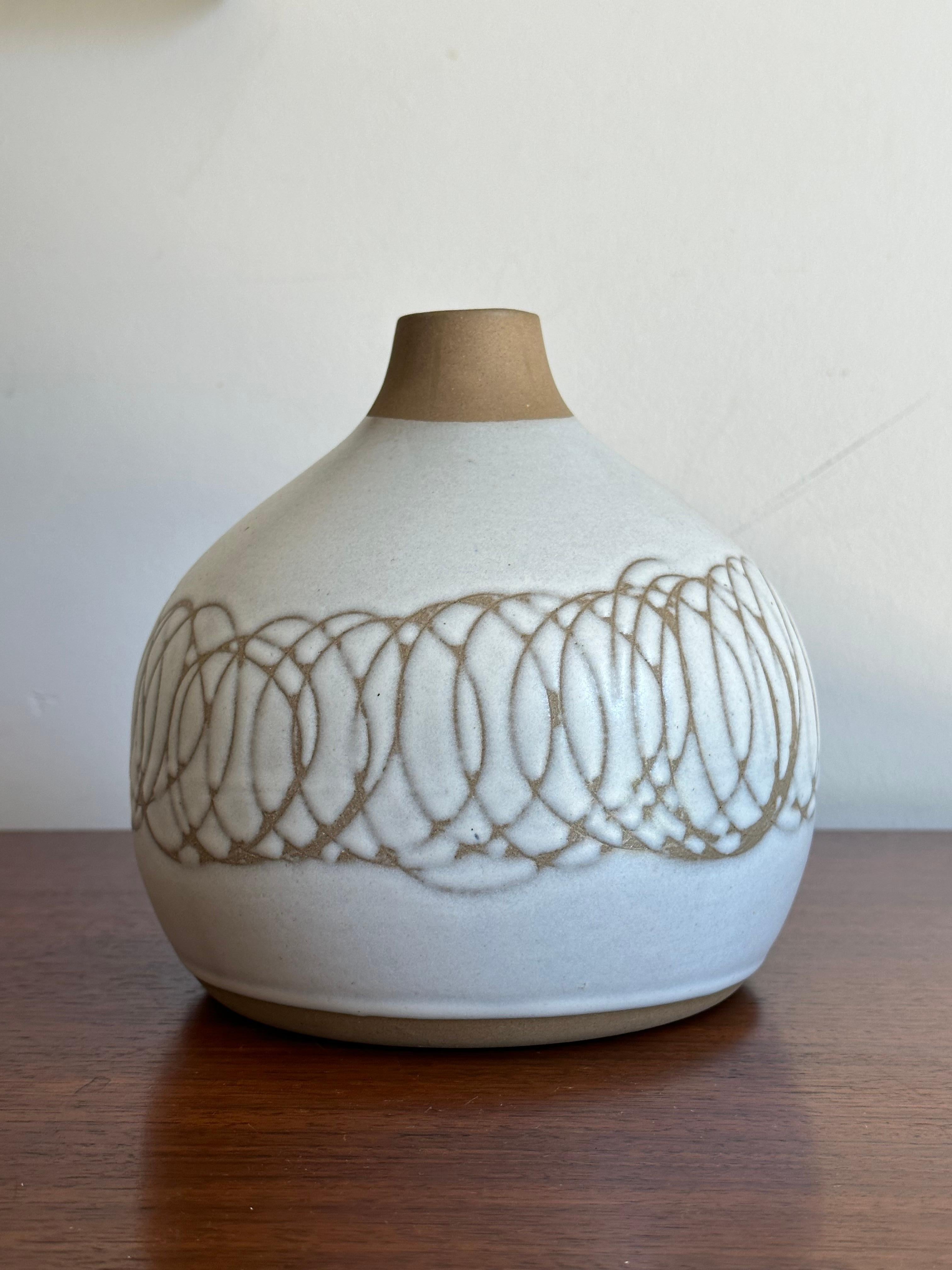 A well proportioned vase produced by Marshall Studios, circa 1970s. This one with a glazed white body with incised unglazed swirls.

Marshall Studios was the infamous company which produced countless lamps by famed ceramicist duo Jane and Gordon