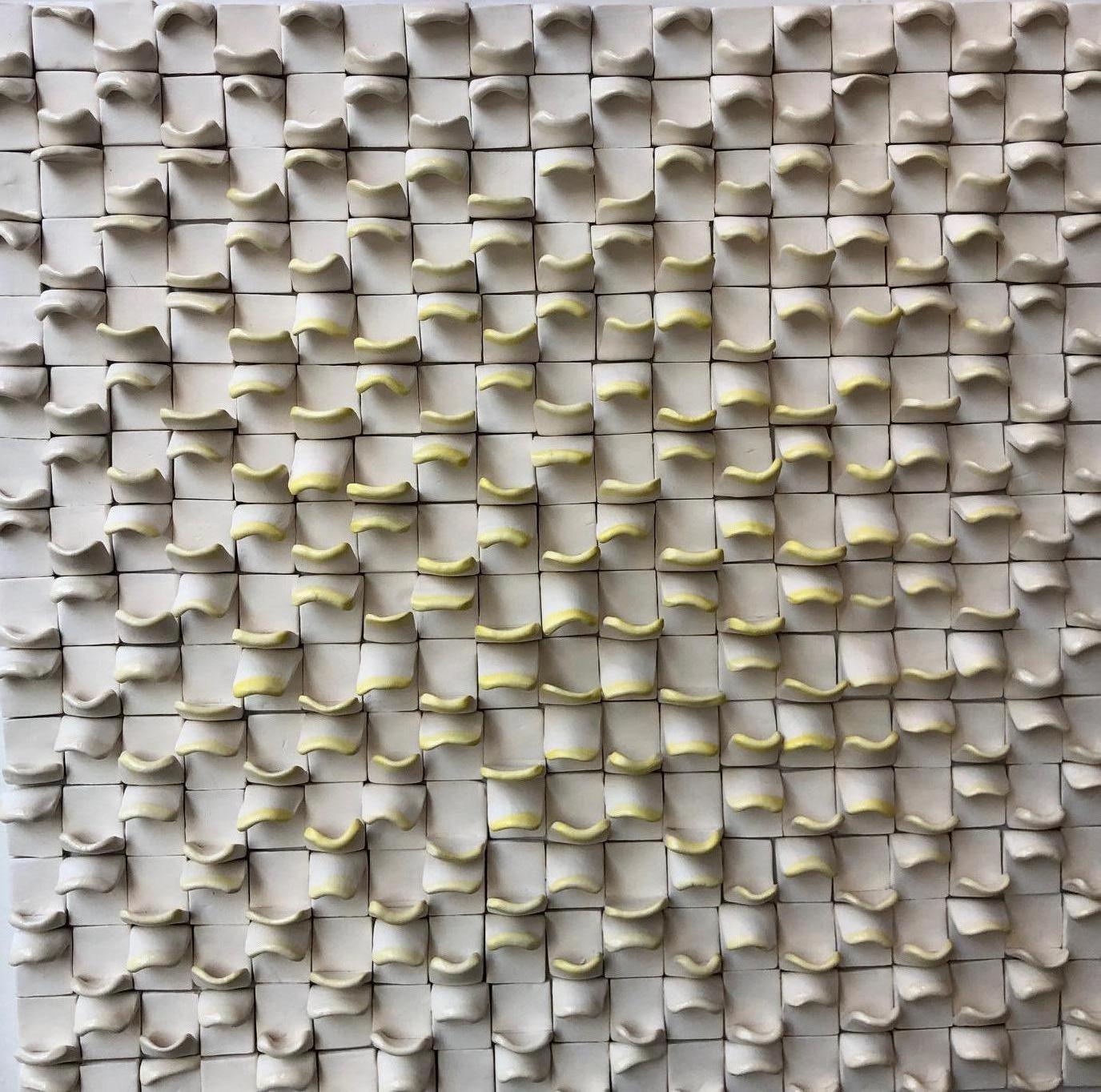 Abstract Ceramic wall sculpture in white with ivory/yellow from Pop Art pioneer Jane B. Grimm, whose minimal and meditative sculptures and wall reliefs are comprised of ceramic, using a low fire method. New works take their inspiration from nature,