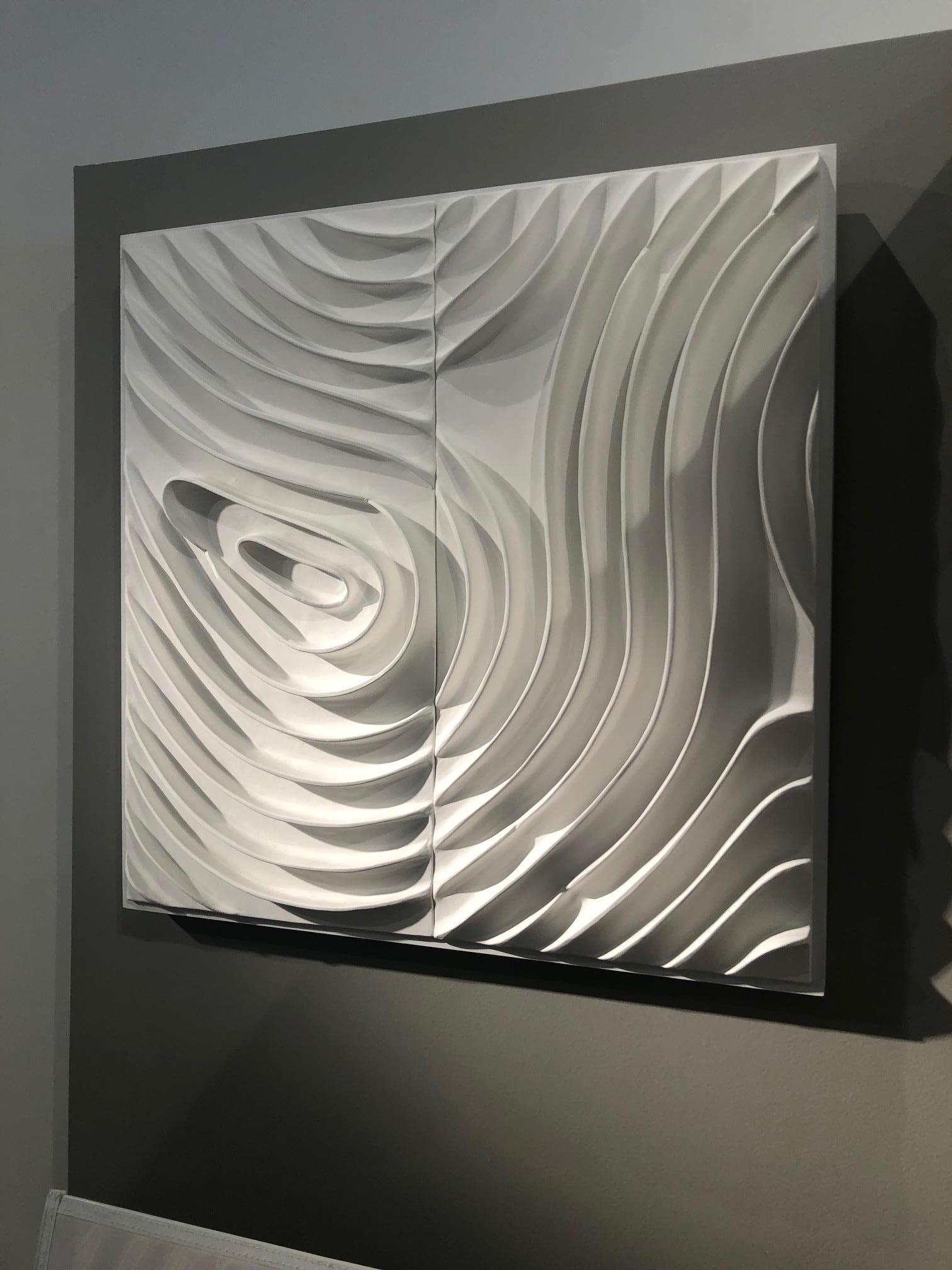 Original abstract ceramic sculptural wall mounted work. The unique piece of art is created with matte white ceramic that is mounted to a white wood panel, and it hangs traditionally like a painting, with wire on the back. A beautiful, minimal work