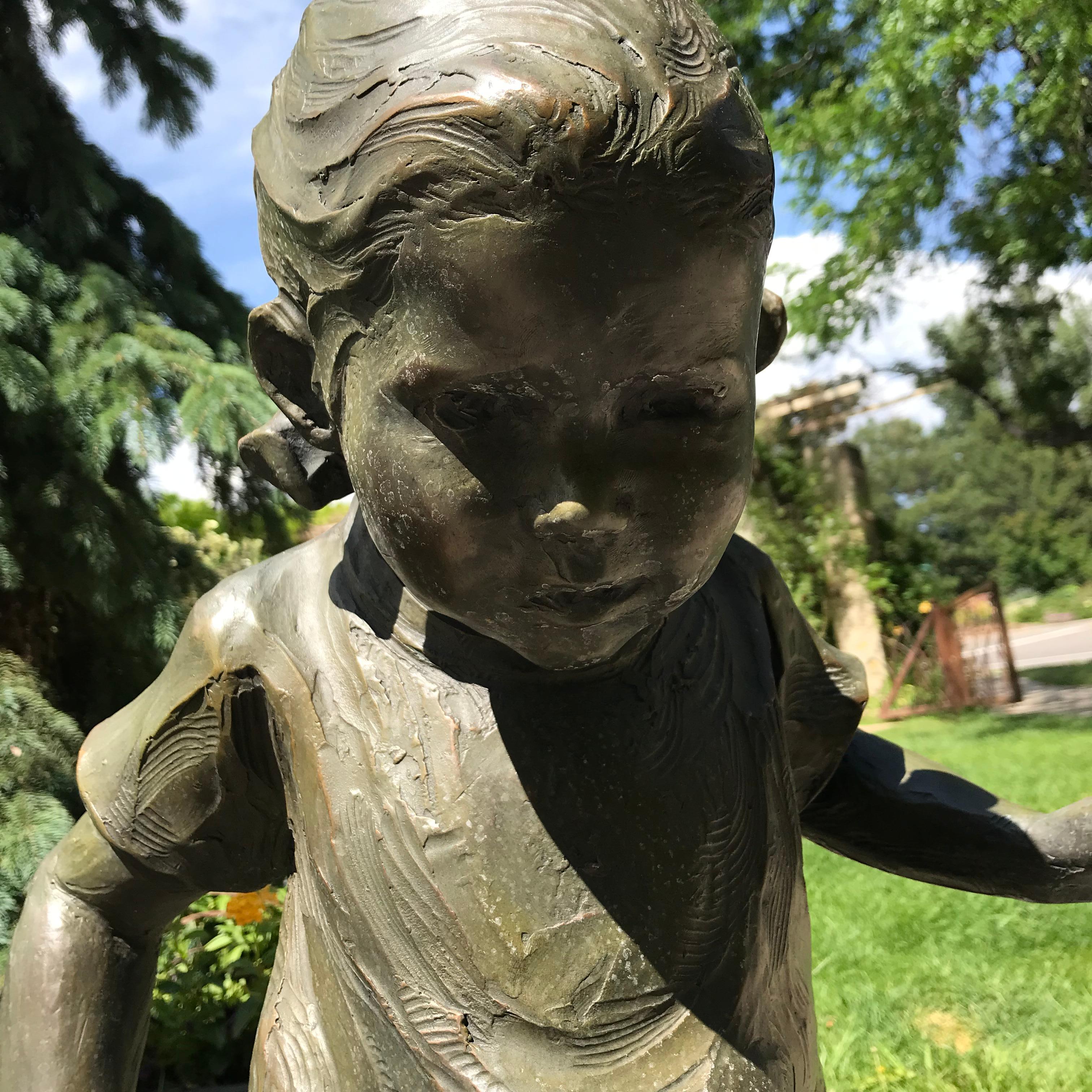 Julie is a figurative bronze sculpture depicting a young girl carefully balancing her way across a narrow path. Finished with a greenish-hued patina, this sculpture fits any garden or entry in its playful sophistication. The child is 28