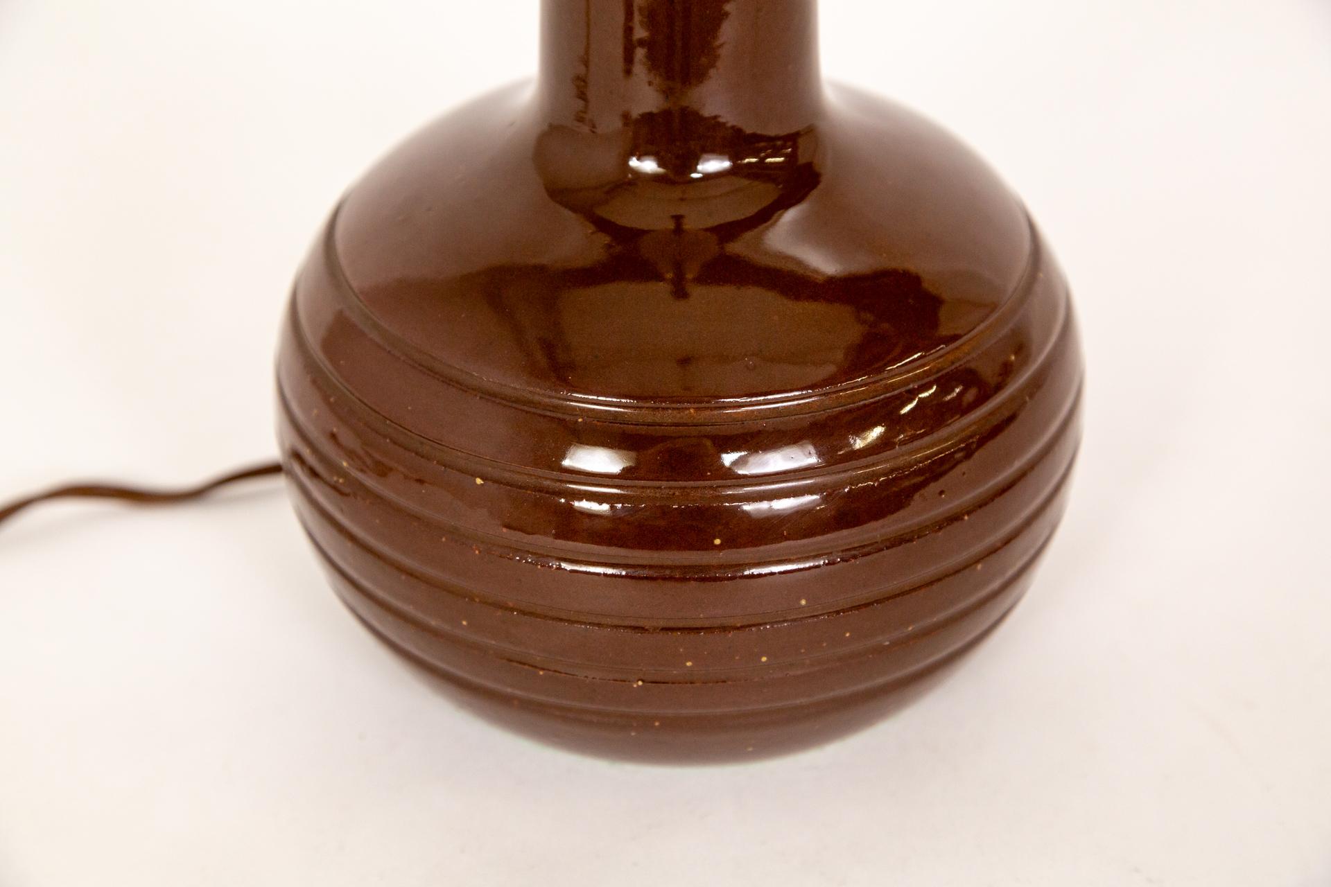 Petite lampe en céramique aux lignes épurées et à la glaçure brillante d'un brun rouge profond, fabriquée par Marshall Studios et conçue par Jane et Gordon Martz, vers les années 1960.  Signé au dos.  Câblage d'origine, vérifié par nos techniciens