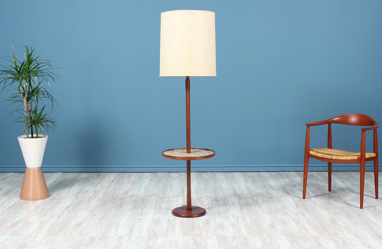 Dazzling floor lamp side table designed by Jane & Gordon Martz for Marshall Studios in the United States circa 1950’s. This stylish lamp features an integrated circular table with ceramic tile inlay in earthy tones that pair beautifully with the
