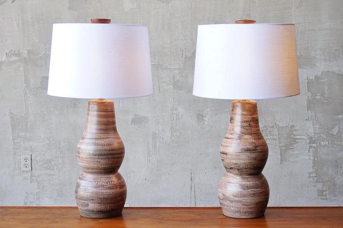 Beautifully crafted pair of glazed ceramic table lamps with hand applied decorative incisions by Jane and Gordon Martz for Marshall Studios, circa 1960s.

Both in excellent original condition, with incredible original solid walnut finials