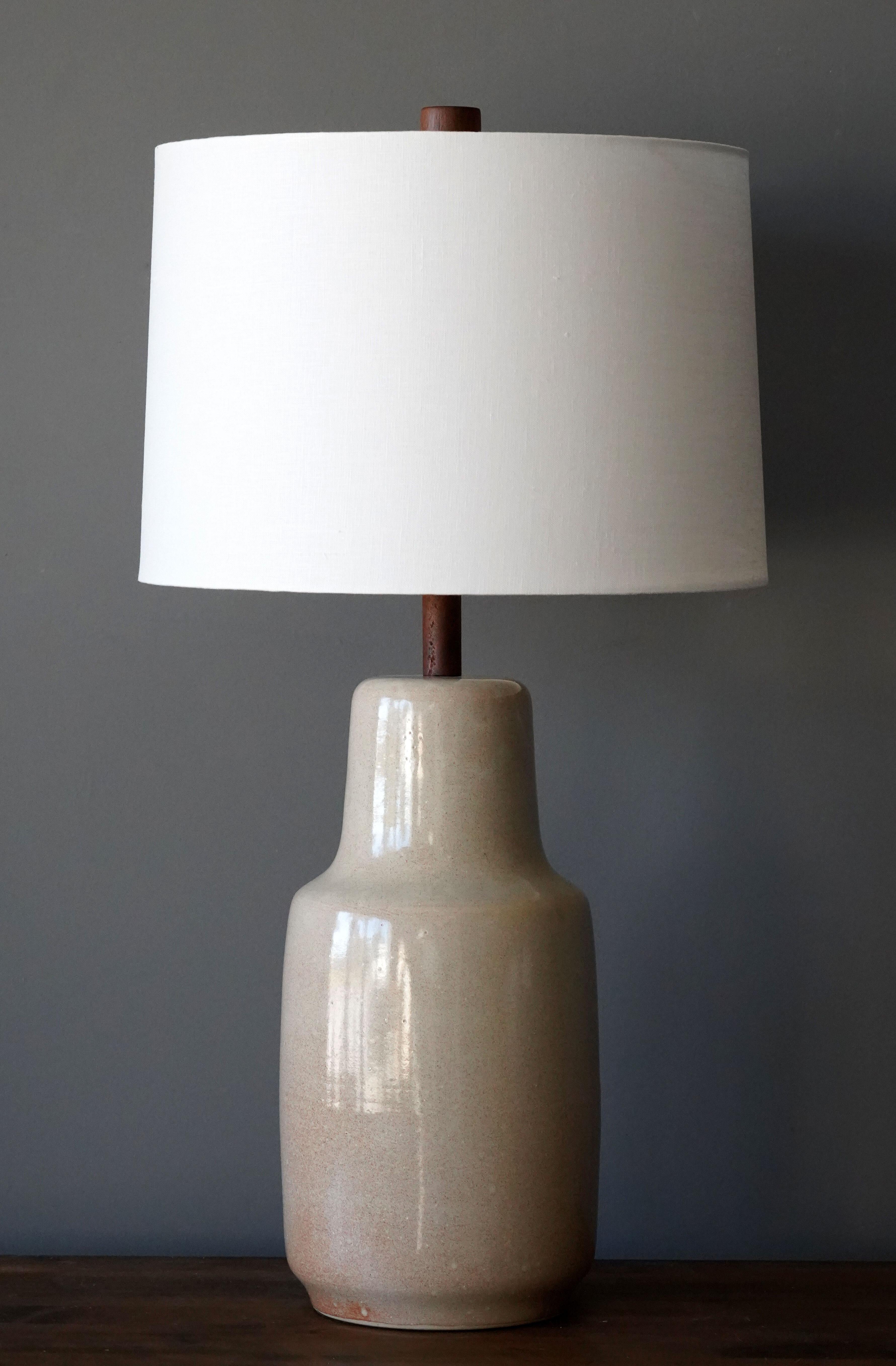A table lamp designed by husband and wife duo Jane & Gordon Martz. Produced by Marshall Studios, Indianapolis. 

Bases are slip-cast and then dipped into glaze. Design also incorporates exquisite walnut necks and finials. Bases are signed.