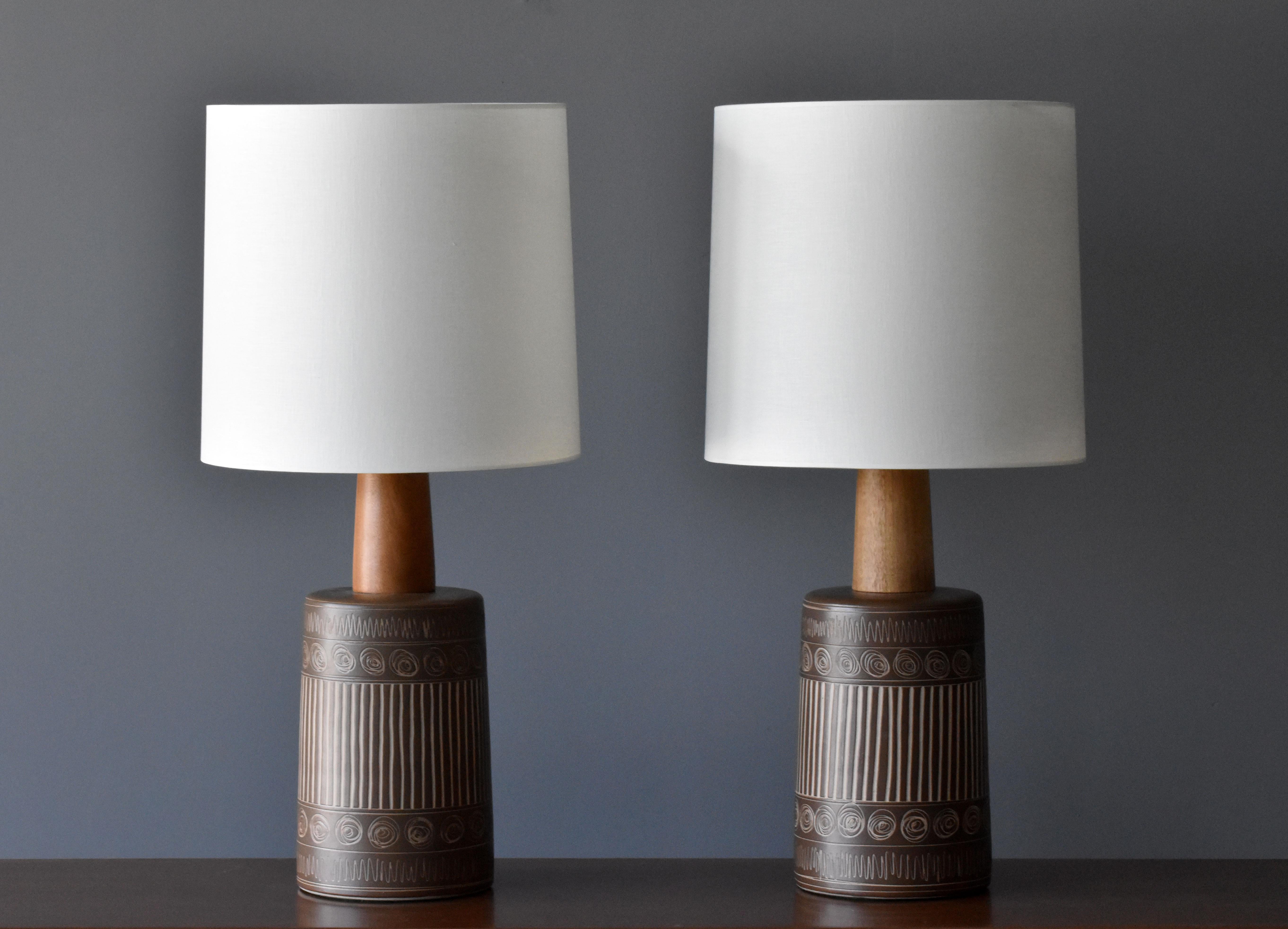 A pair of large table lamps designed by husband and wife duo Jane & Gordon Martz. Produced by Marshall Studios, Indianapolis. 

Bases are slip-cast and then dipped into glaze and hand painted. Design also incorporates exquisite walnut necks and