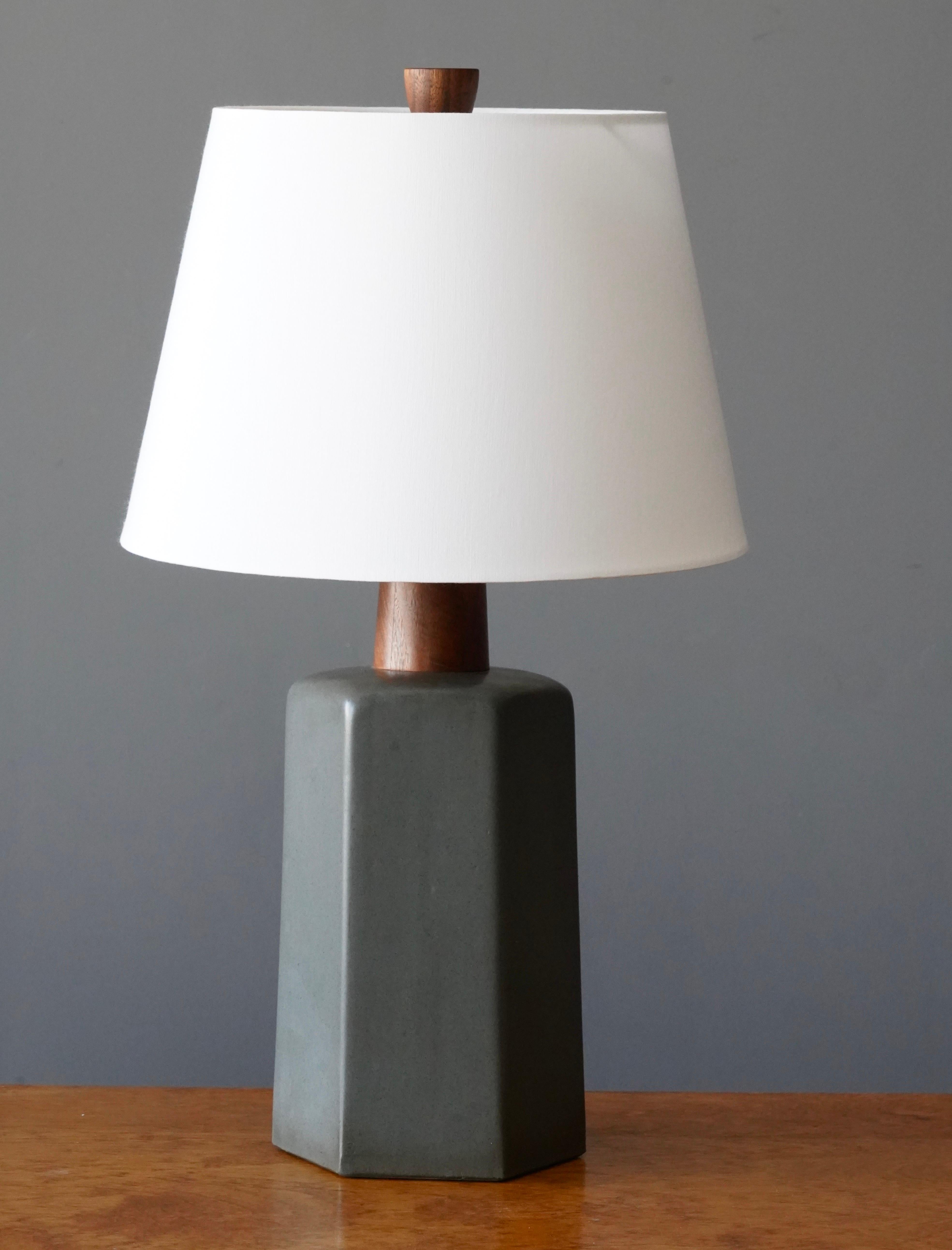 A table lamp designed by husband and wife duo Jane & Gordon Martz. Produced by Marshall Studios, Indianapolis. 

The base is slip-cast and then dipped into glaze and hand painted. Design also incorporates exquisite walnut neck and finial. Base is