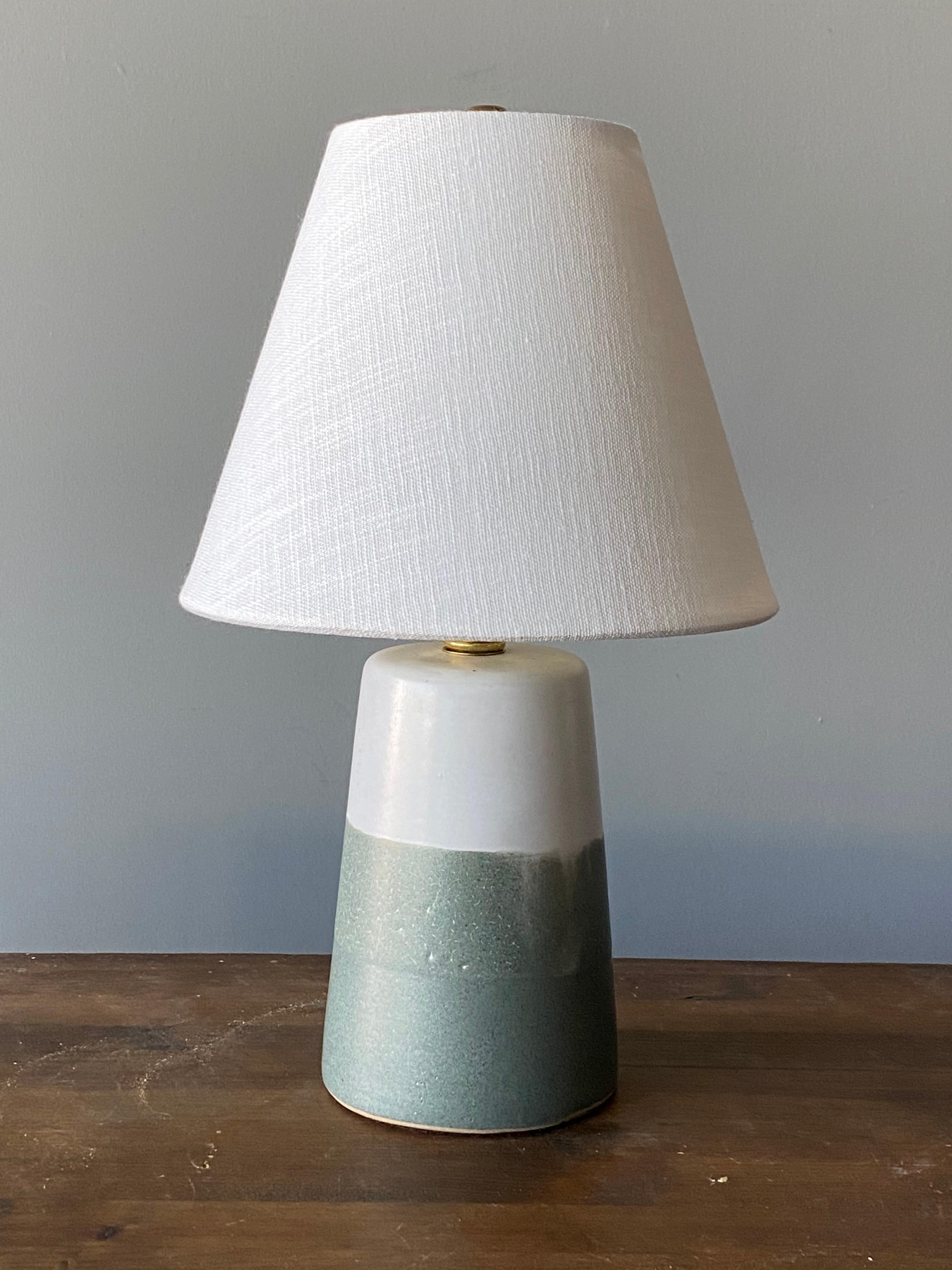 A pair of table lamps designed by husband and wife duo Jane & Gordon Martz. Produced by Marshall Studios, Indianapolis. 

The base is slip-cast and then dipped into glaze and hand painted. Base of one lamp is signed.

Lampshades on bulb-clips are