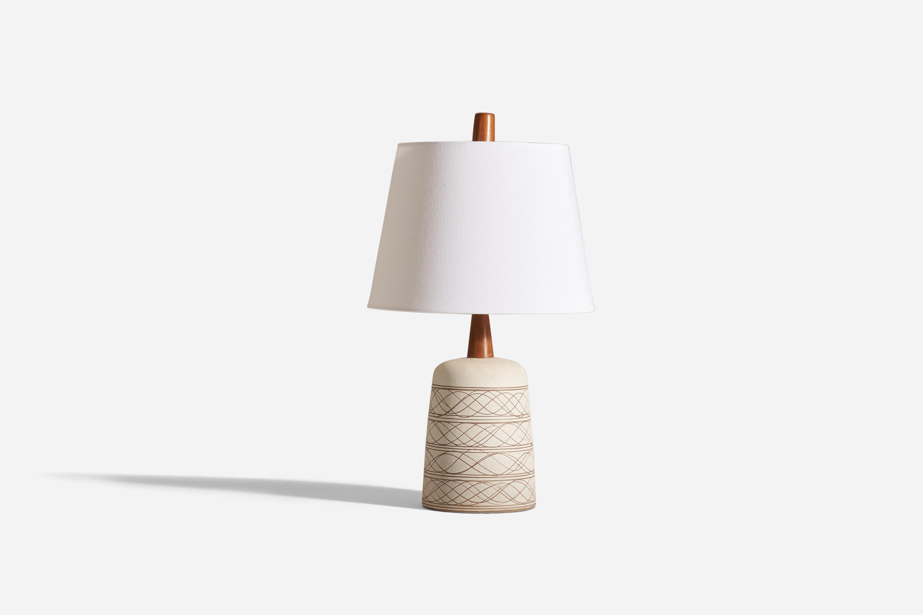 A table lamp designed by husband and wife duo Jane &; Gordon Martz. Produced by Marshall Studios, Indiana. 

The base is slip-cast and then dipped into glaze and hand-painted. The design also incorporates an exquisite walnut neck and finial. The