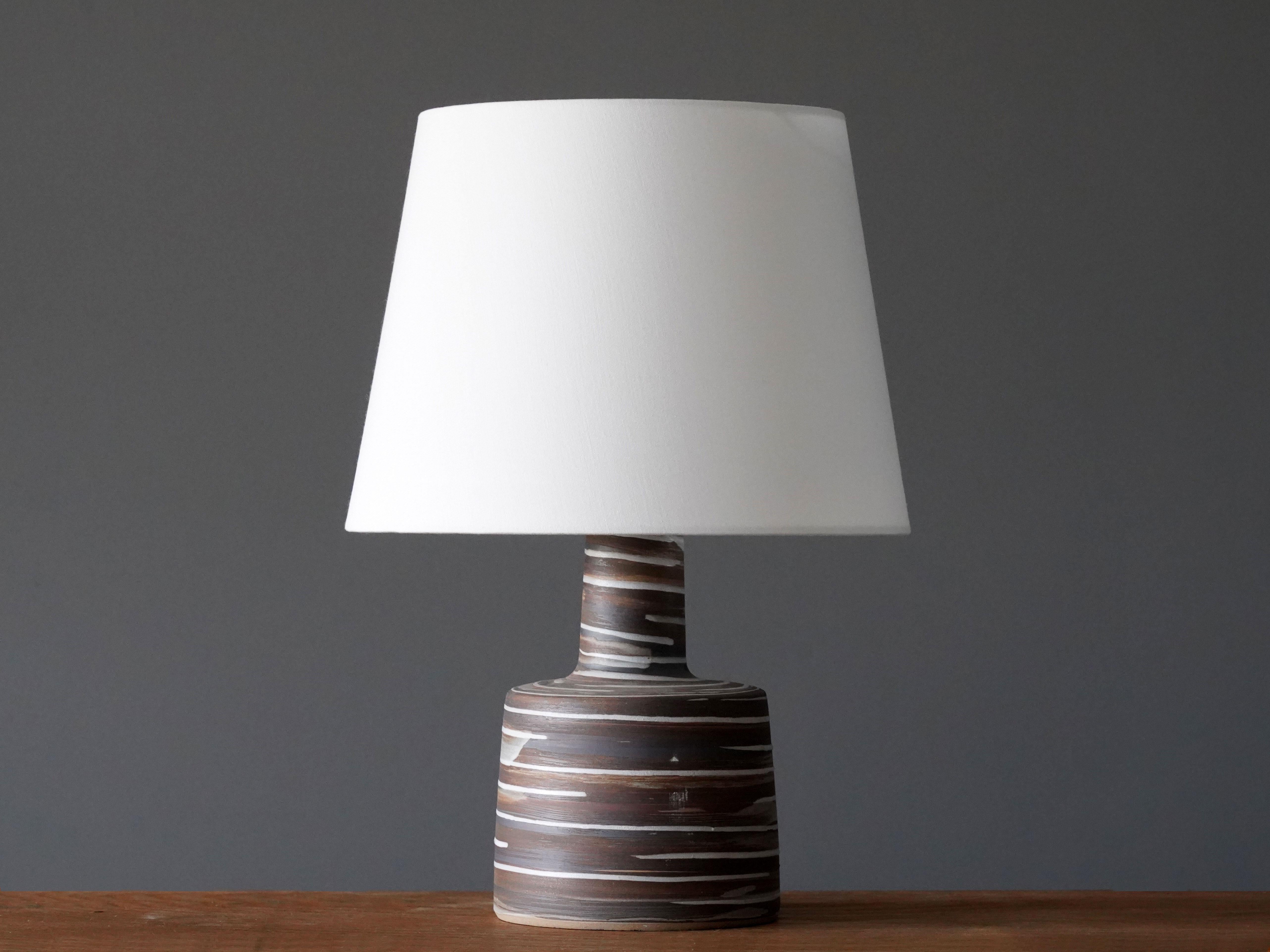 A table lamp designed by husband and wife duo Jane & Gordon Martz. Produced by Marshall Studios, Indianapolis. 

The base is slip-cast and then dipped into glaze and hand-painted. Base is signed. Sold without lampshade.

Jane & Gordon Martz works