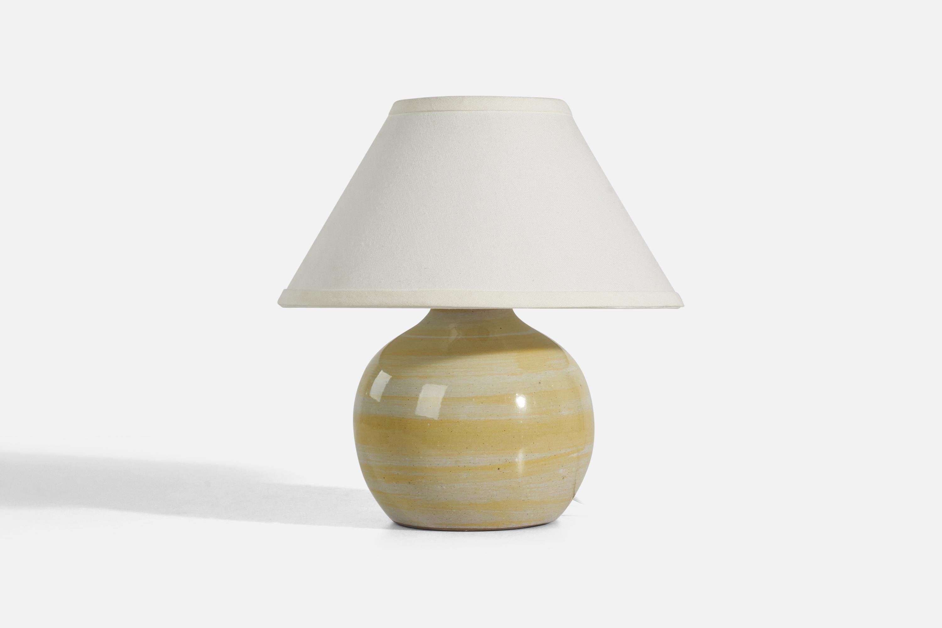 A yellow and white ceramic table lamp designed by Jane & Gordon Martz and produced by Marshall Studios, Indianapolis, 1950s. 

Sold without Lampshade
Dimensions of Lamp (inches) : 9.62 x 7.12 x 7.12 (Height x Width x Depth)
Dimensions of Lampshade