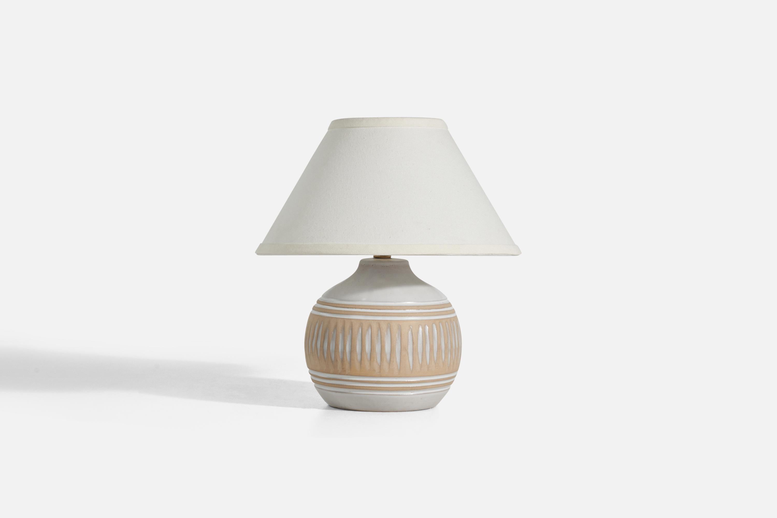 A white and beige ceramic table lamp designed by Jane & Gordon Martz and produced by Marshall Studios, Indianapolis, 1950s. 

Sold without Lampshade
Dimensions of Lamp (inches) : 9.62 x 7.12 x 7.12 (Height x Width x Depth)
Dimensions of Lampshade