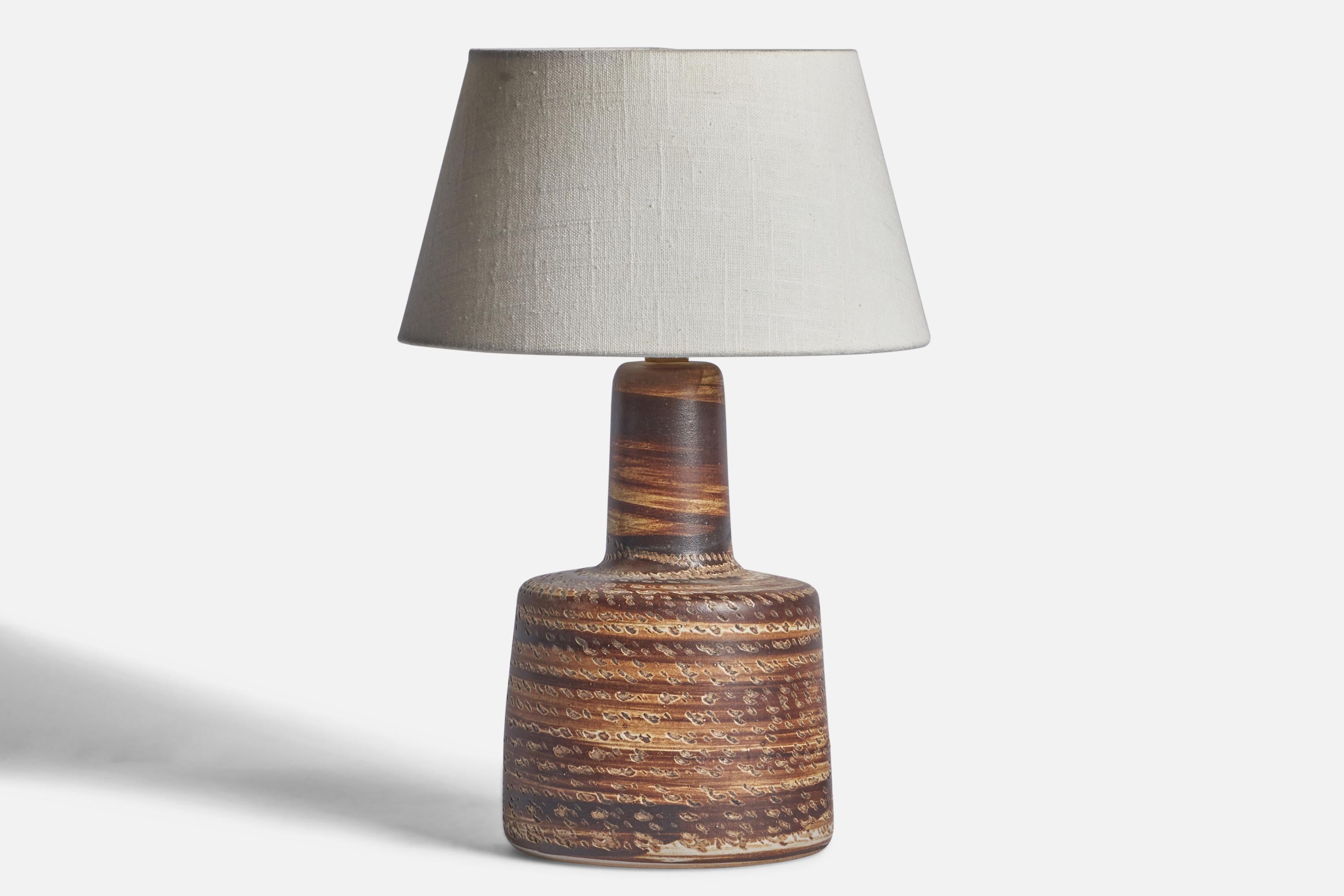 A beige and brown-glazed ceramic table lamp designed by Jane & Gordon Martz and produced by Marshall Studios, USA, 1960s.

Dimensions of Lamp (inches): 12” H x 6.25” Diameter
Dimensions of Shade (inches): 7” Top Diameter x 10” Bottom Diameter x 5.5”