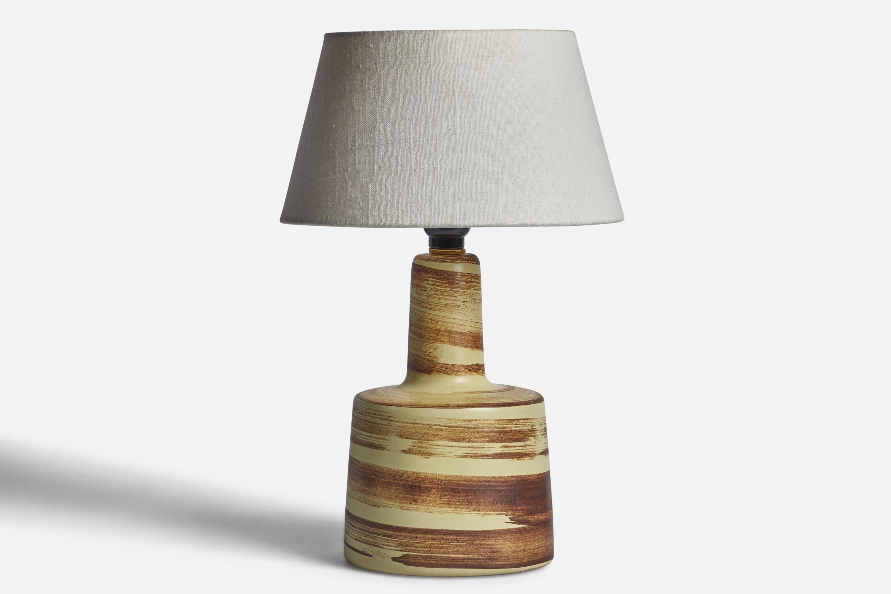 A beige and brown-glazed ceramic table lamp designed by Jane & Gordon Martz and produced by Marshall Studios, USA, 1960s.

Dimensions of Lamp (inches): 12” H x 6.15” Diameter
Dimensions of Shade (inches): 7” Top Diameter x 10” Bottom Diameter x 5.5”