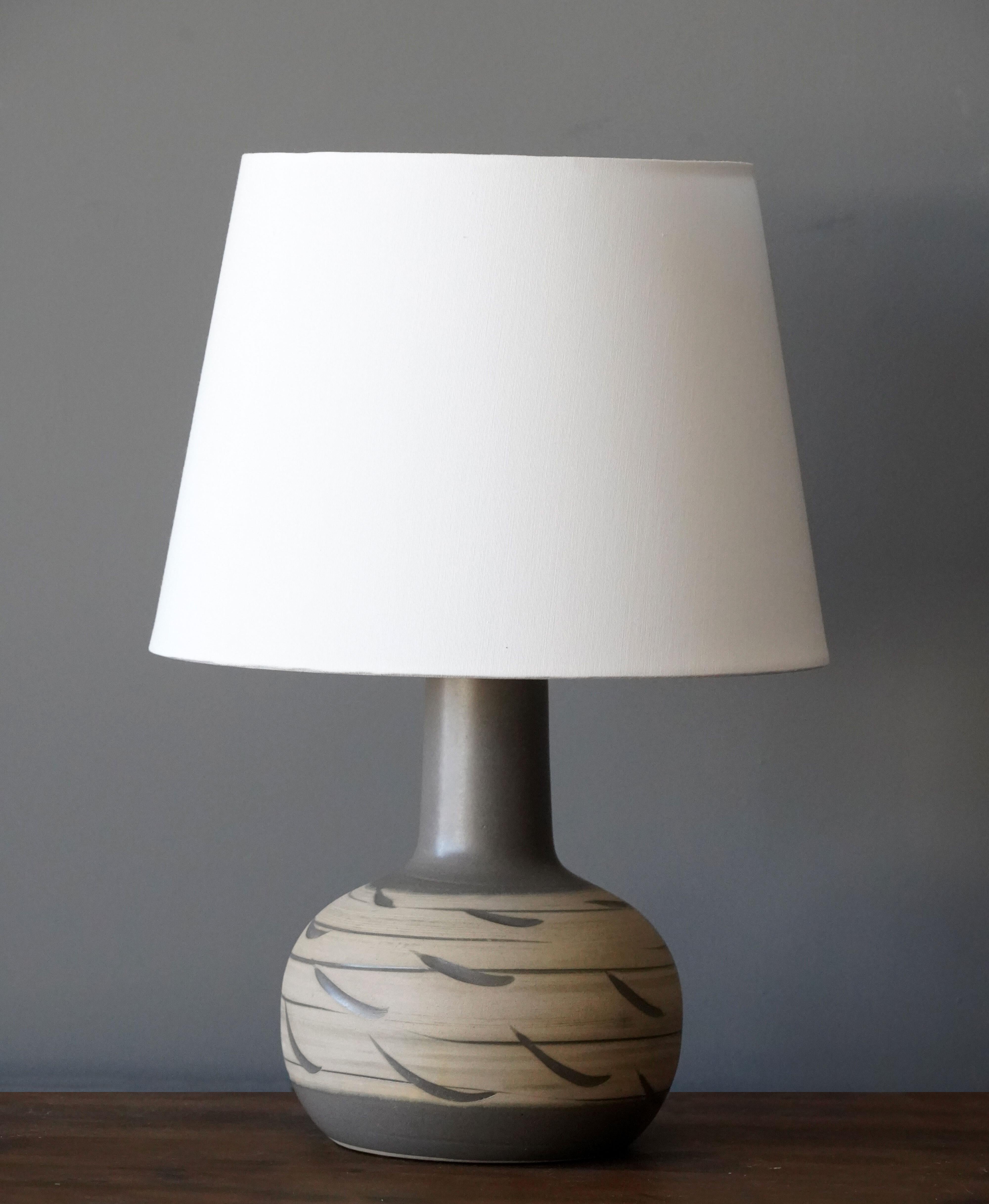 A table lamp designed by husband and wife duo Jane & Gordon Martz. Produced by Marshall Studios, Indianapolis. 

The base is slip-cast and then dipped into glaze and hand painted. Base is signed.

Jane & Gordon Martz works are represented in the