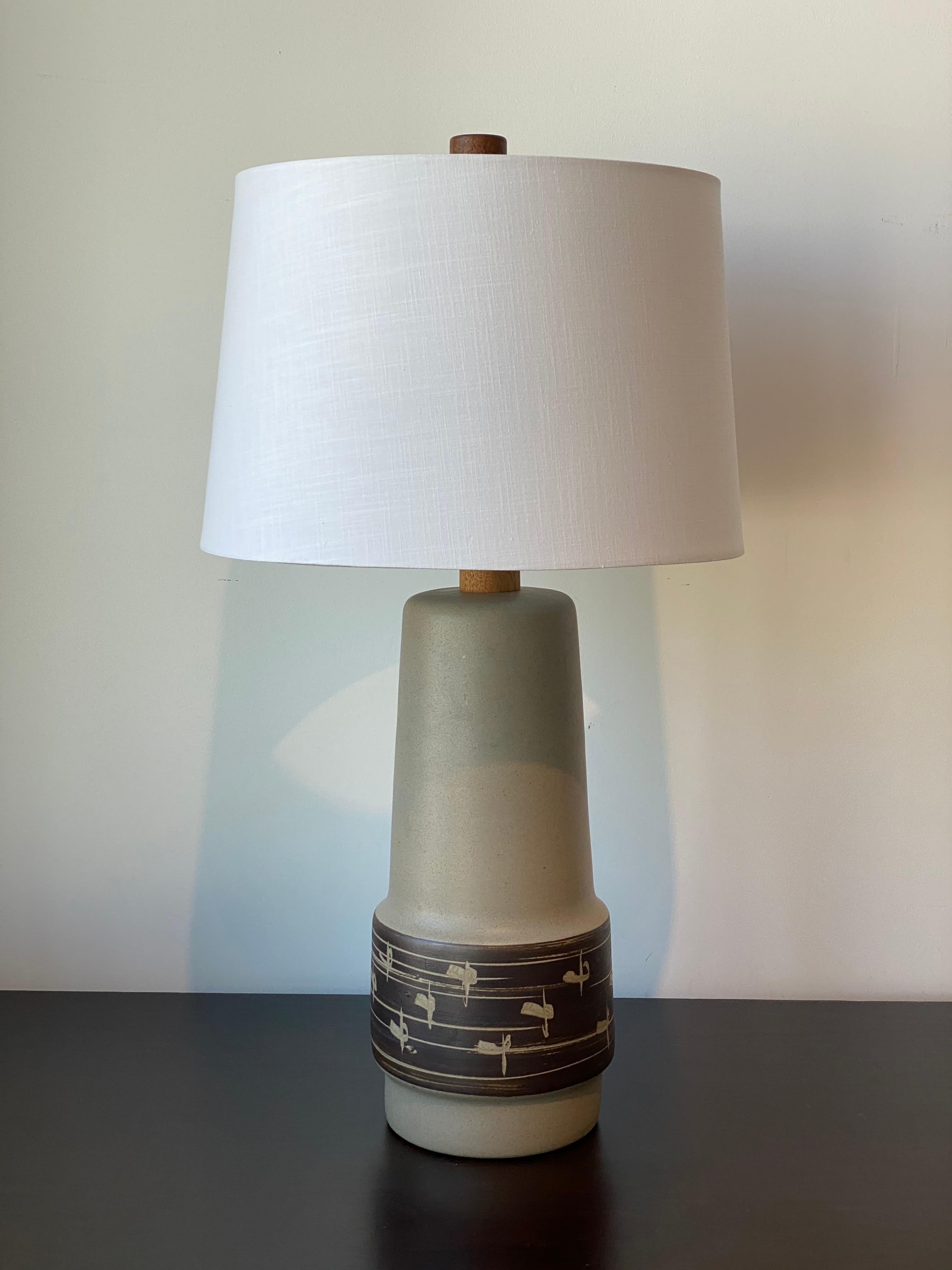 A table lamp designed by husband and wife duo Jane & Gordon Martz. Produced by Marshall Studios, Indianapolis. 

Bases are slip-cast and then dipped into glaze and hand painted. Design also incorporates exquisite walnut necks and finials. Bases are