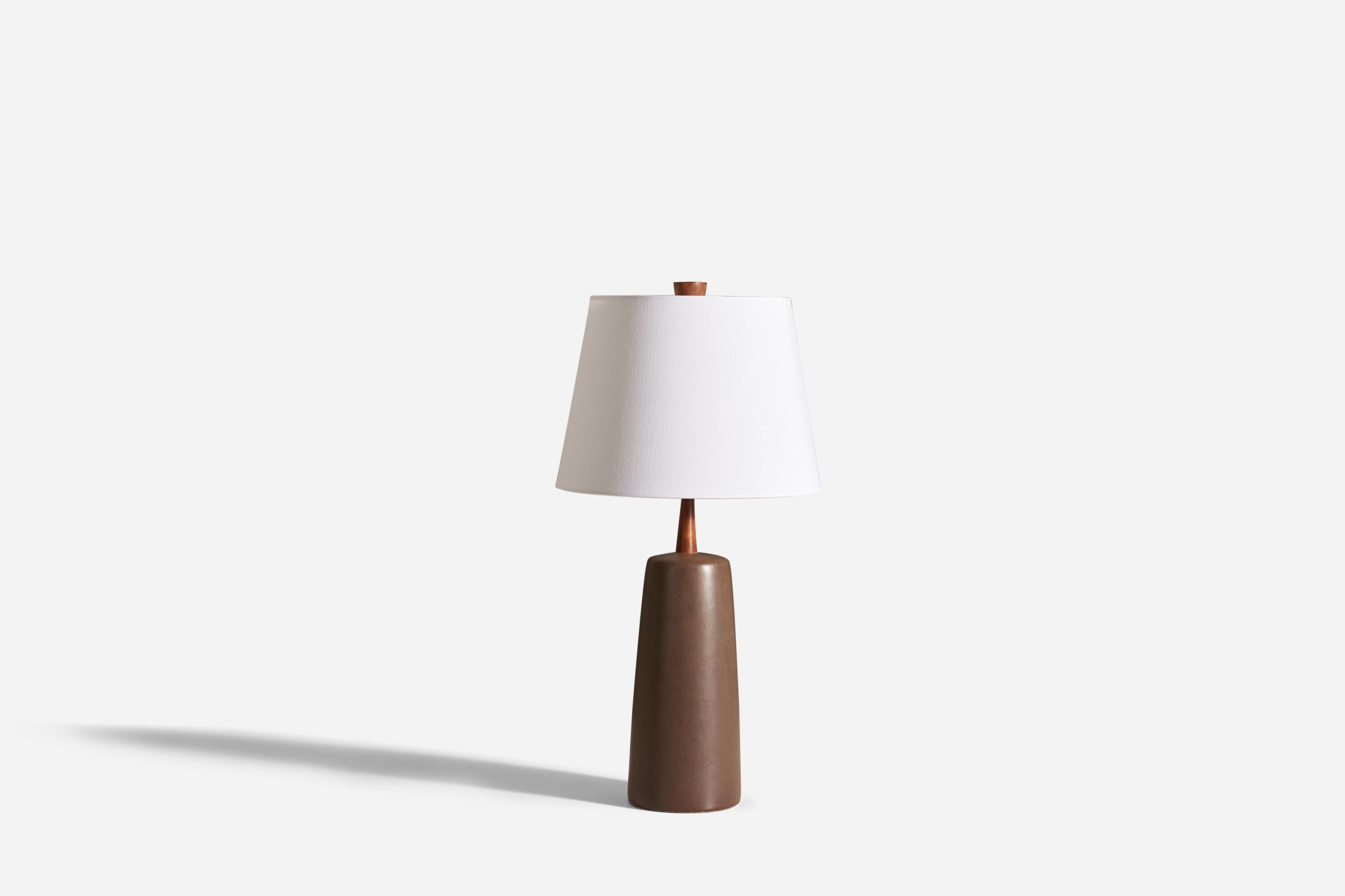 A table lamp designed by husband and wife duo Jane & Gordon Martz. Produced by Marshall Studios, Indiana.

The base is slip-cast and then dipped into glaze. The design also incorporates an exquisite walnut neck and finial. The base is signed.