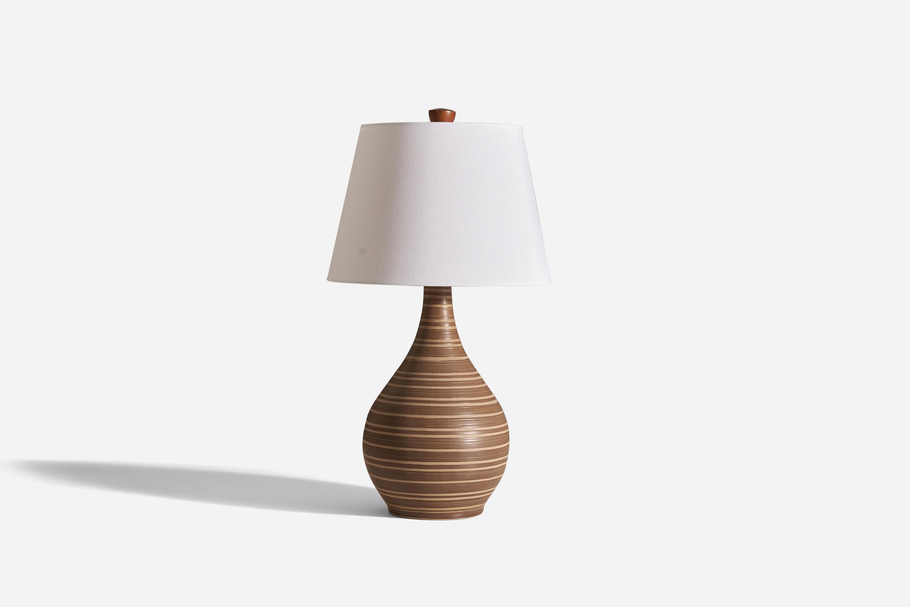 A table lamp designed by husband and wife duo Jane & Gordon Martz. It was produced by Marshall Studios in Indianapolis. 

The base is slip-cast, then dipped into a glaze, and hand-painted. The design also incorporates an exquisite walnut neck and