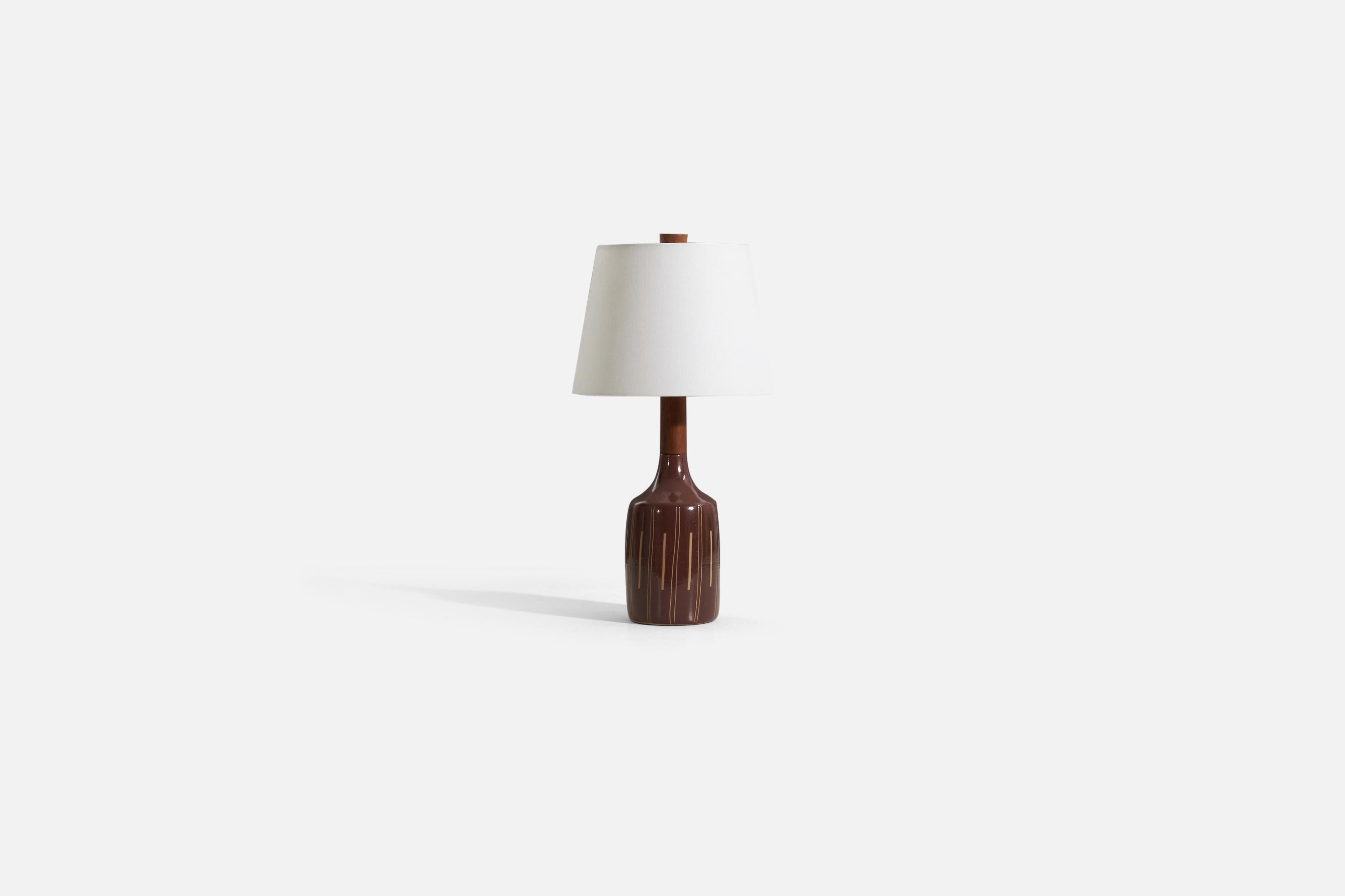 A table lamp designed by husband and wife duo Jane & Gordon Martz. Produced by Marshall Studios, Indianapolis. 

The base is slip-cast and then dipped into glaze and hand-painted. The design also incorporates an exquisite walnut neck and finial.