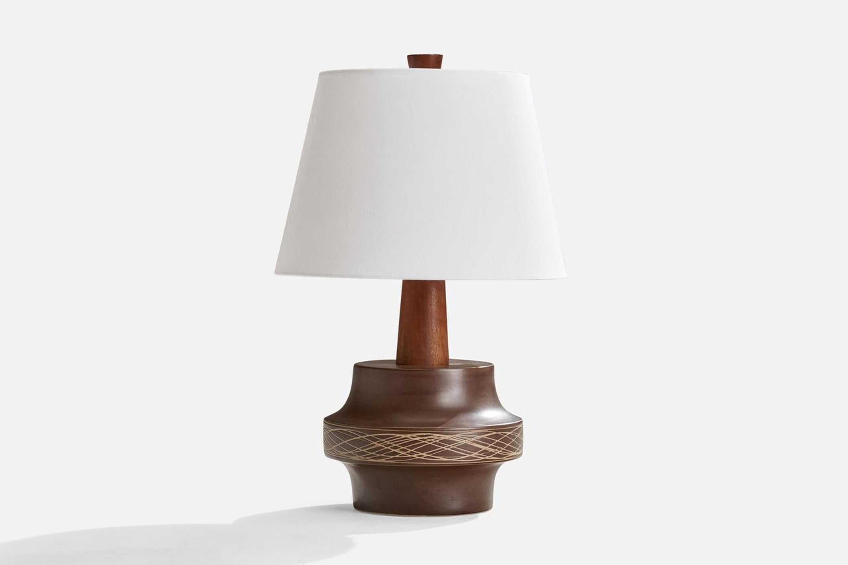 A brown-glazed ceramic and walnut table lamp designed by Jane & Gordon Martz and produced by Marshall Studios, USA, c. 1950s.

Dimensions of Lamp (inches): 14” H x 10” Diameter
Dimensions of Shade (inches): 10