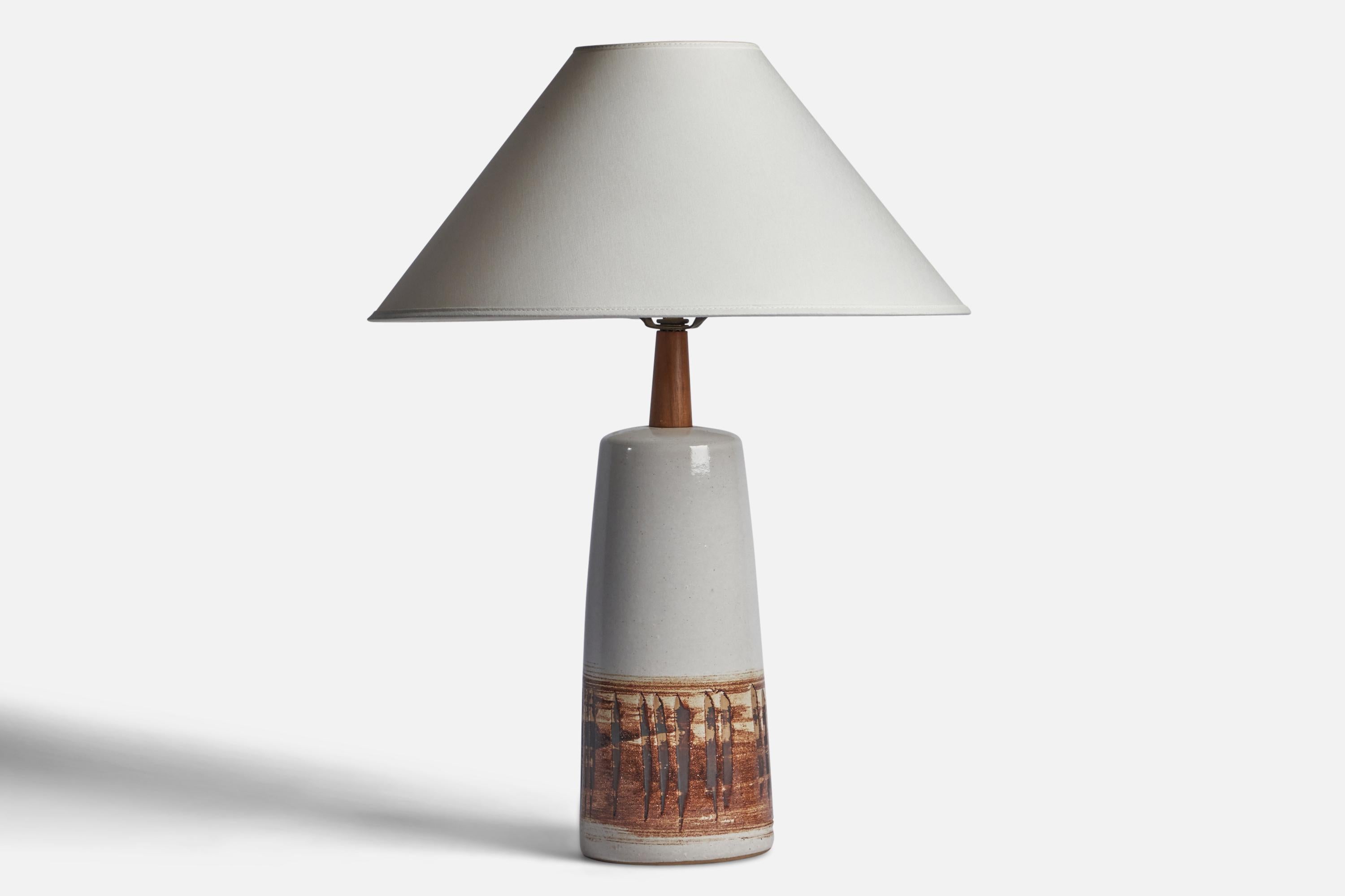 An off-white and brown-glazed ceramic and walnut table lamp designed by Jane & Gordon Martz and produced by Marshall Studios, USA, 1960s.

Dimensions of Lamp (inches): 16.75” H x 5.2” Diameter
Dimensions of Shade (inches): 4.5” Top Diameter x 16”