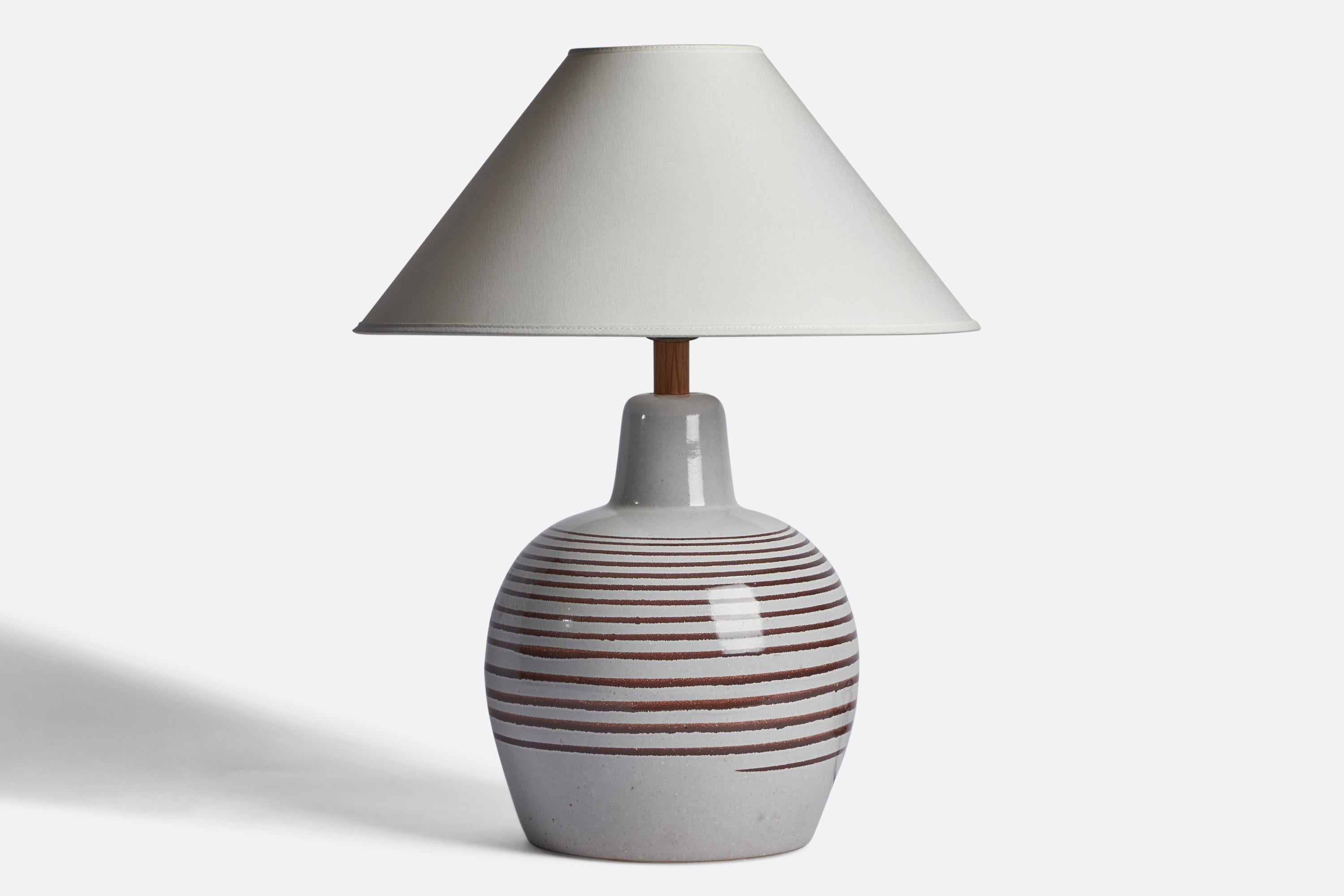 An off-white and brown-glazed ceramic and walnut table lamp designed by Jane & Gordon Martz and produced by Marshall Studios, USA, 1960s.

Dimensions of Lamp (inches): 16.15” H x 9.25” Diameter
Dimensions of Shade (inches): 4.5” Top Diameter x 16”