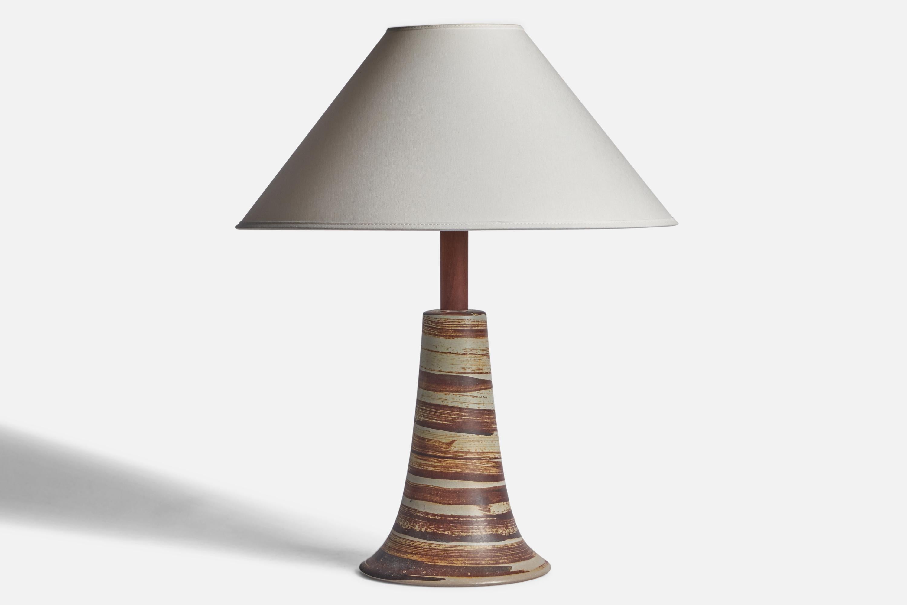 An grey and brown and black-glazed ceramic and walnut table lamp designed by Jane & Gordon Martz and produced by Marshall Studios, USA, 1960s.

Dimensions of Lamp (inches): 15.5” H x 7” Diameter

Dimensions of Shade (inches): 4.5” Top Diameter x 16”