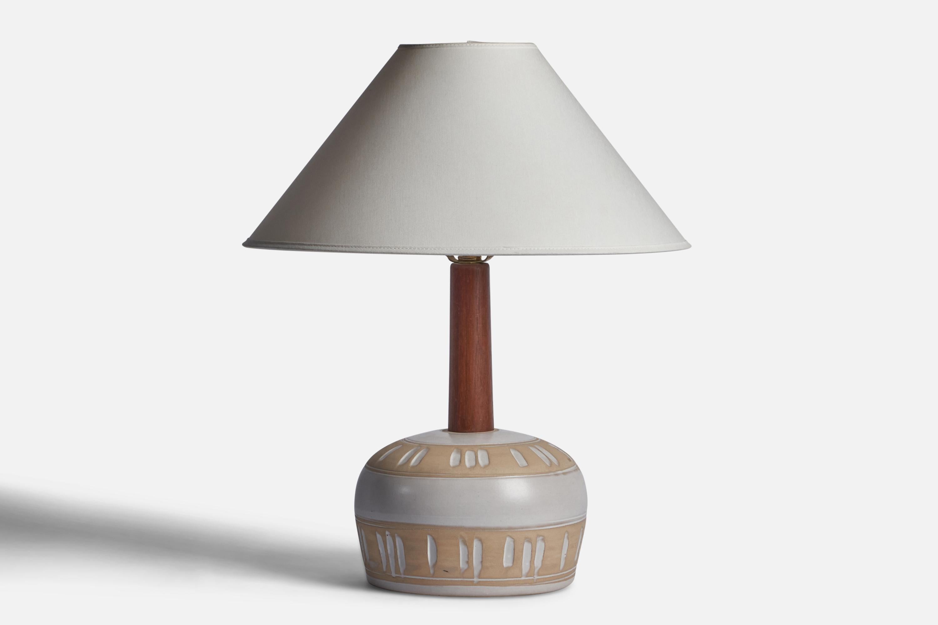 A beige and white-glazed ceramic and walnut table lamp designed by Jane & Gordon Martz and produced by Marshall Studios, USA, 1960s.

Dimensions of Lamp (inches): 14.5” H x 8.3” Diameter
Dimensions of Shade (inches): 4.5” Top Diameter x 16” Bottom