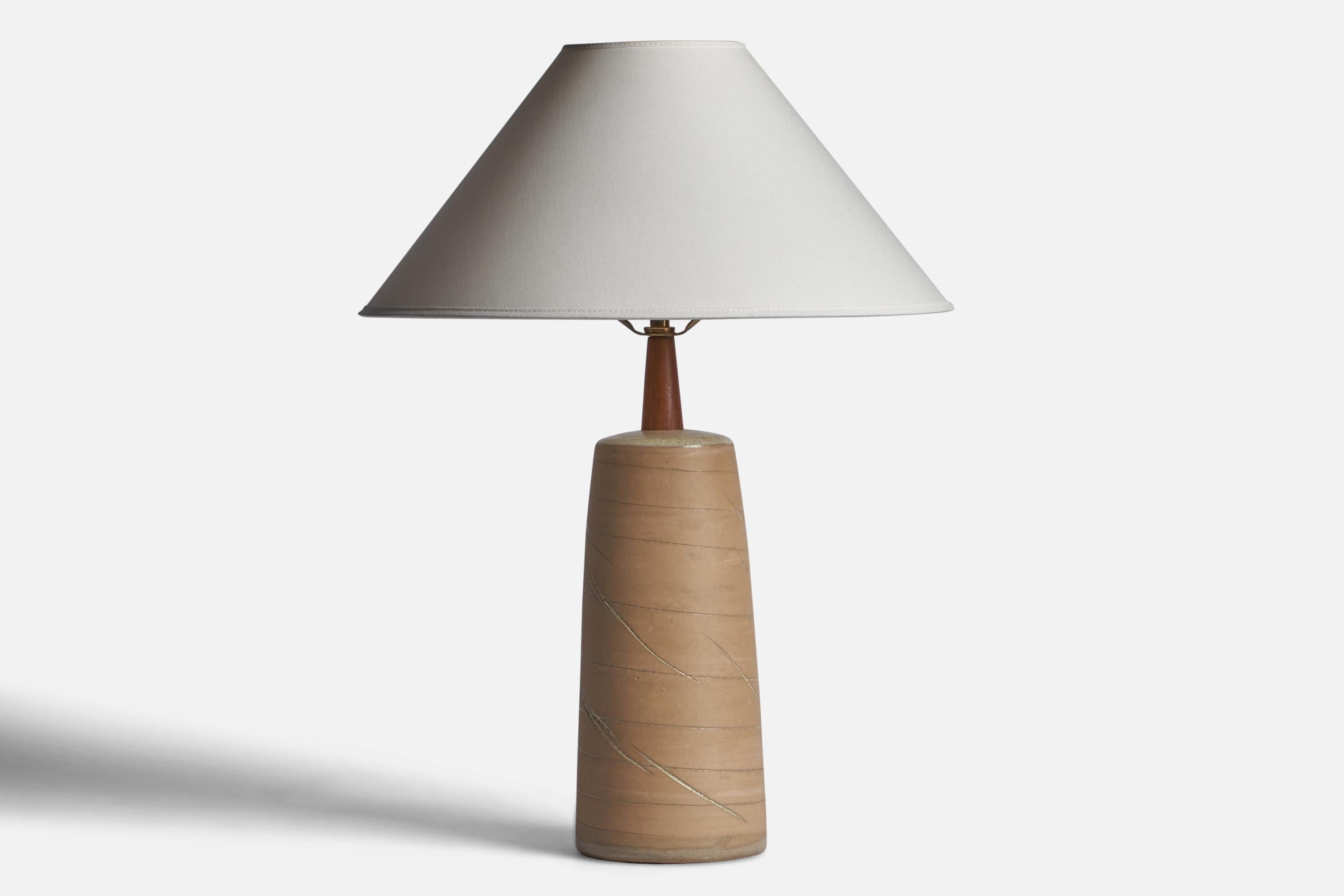 A beige-glazed ceramic and walnut table lamp designed by Jane & Gordon Martz and produced by Marshall Studios, USA, 1960s.

Dimensions of Lamp (inches): 16.95” H x 5.1” Diameter
Dimensions of Shade (inches): 4.5” Top Diameter x 16” Bottom Diameter x